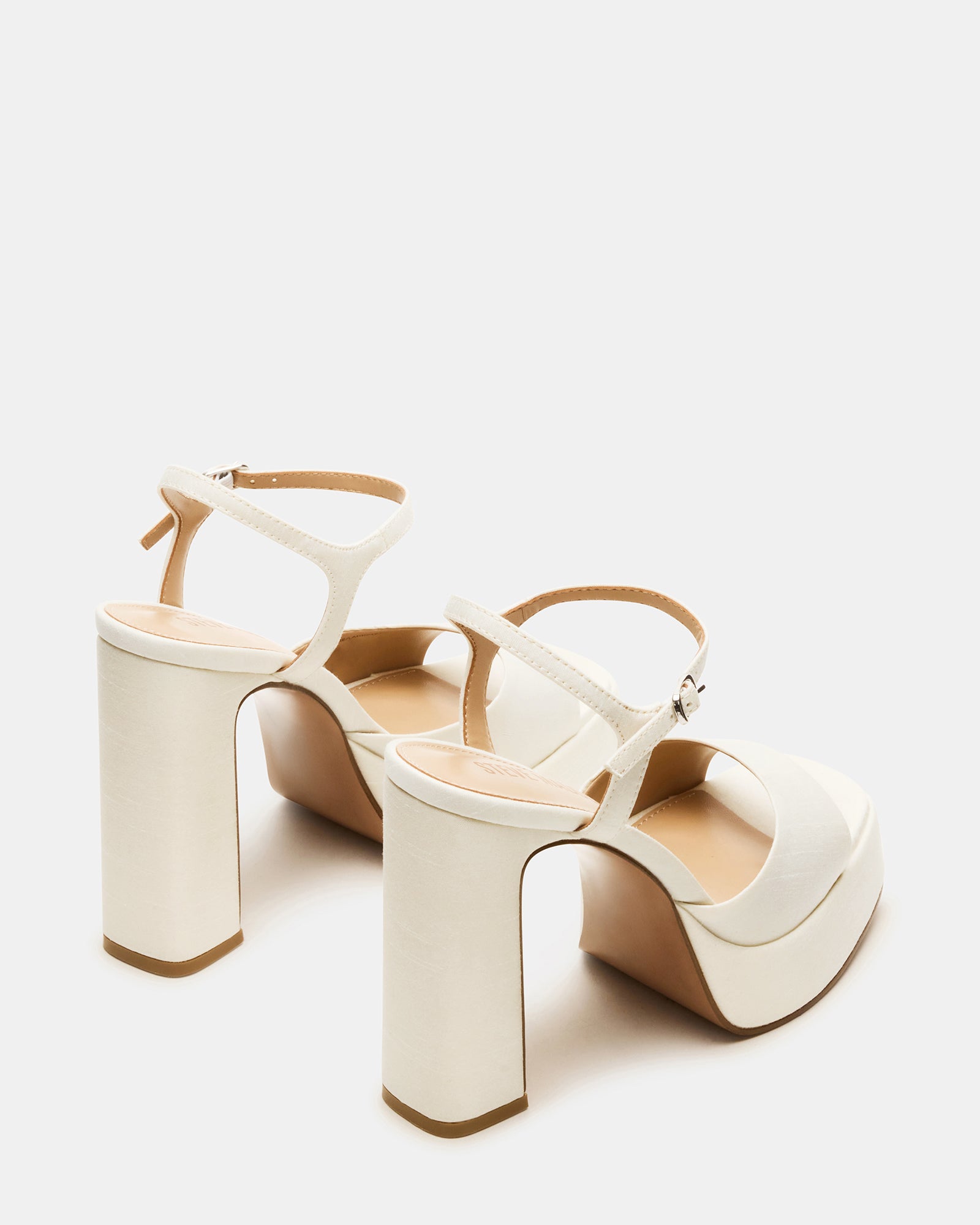 Ivory satin platform block heels styled with a chic outfit for a night out.