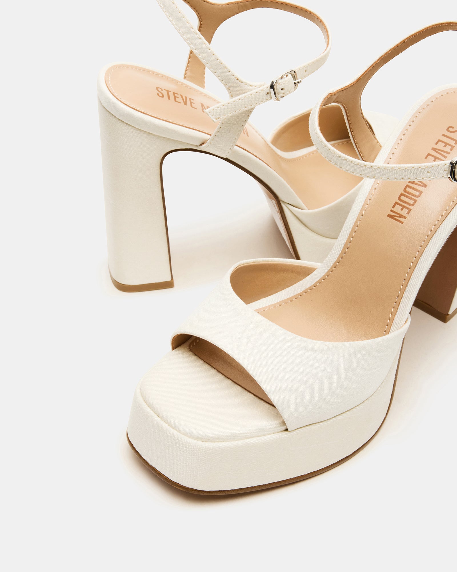 Close-up of ivory satin platform block heels showcasing the square toe design.