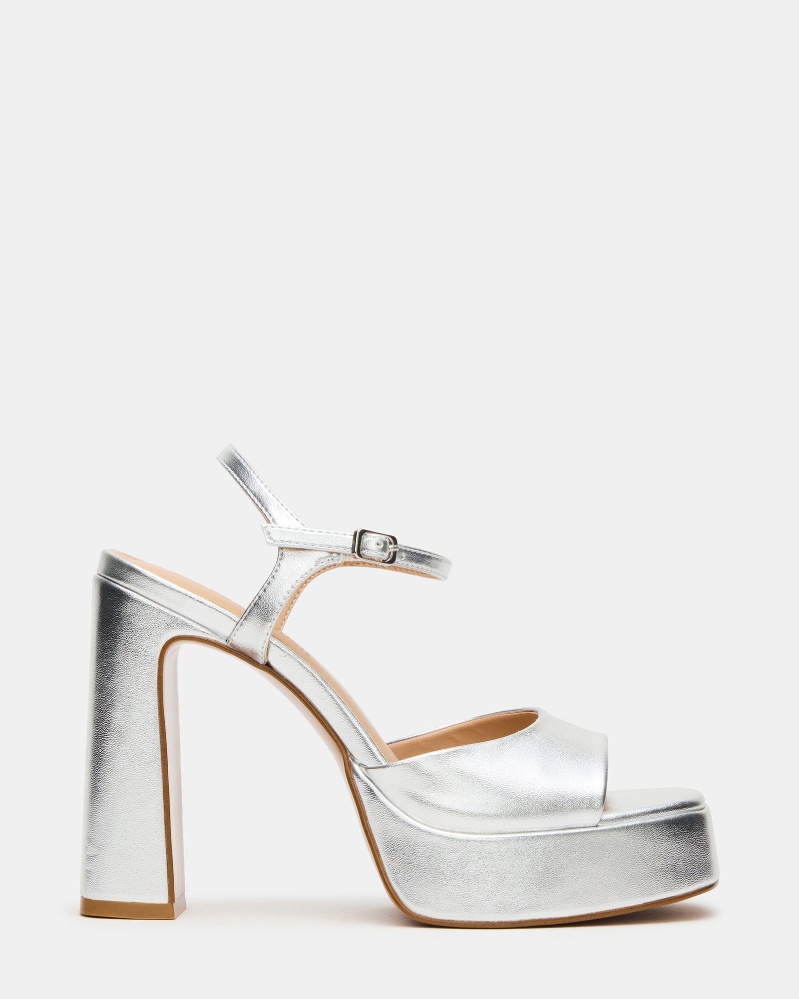 Close-up side view of silver platform shoes with black heels on polished flooring