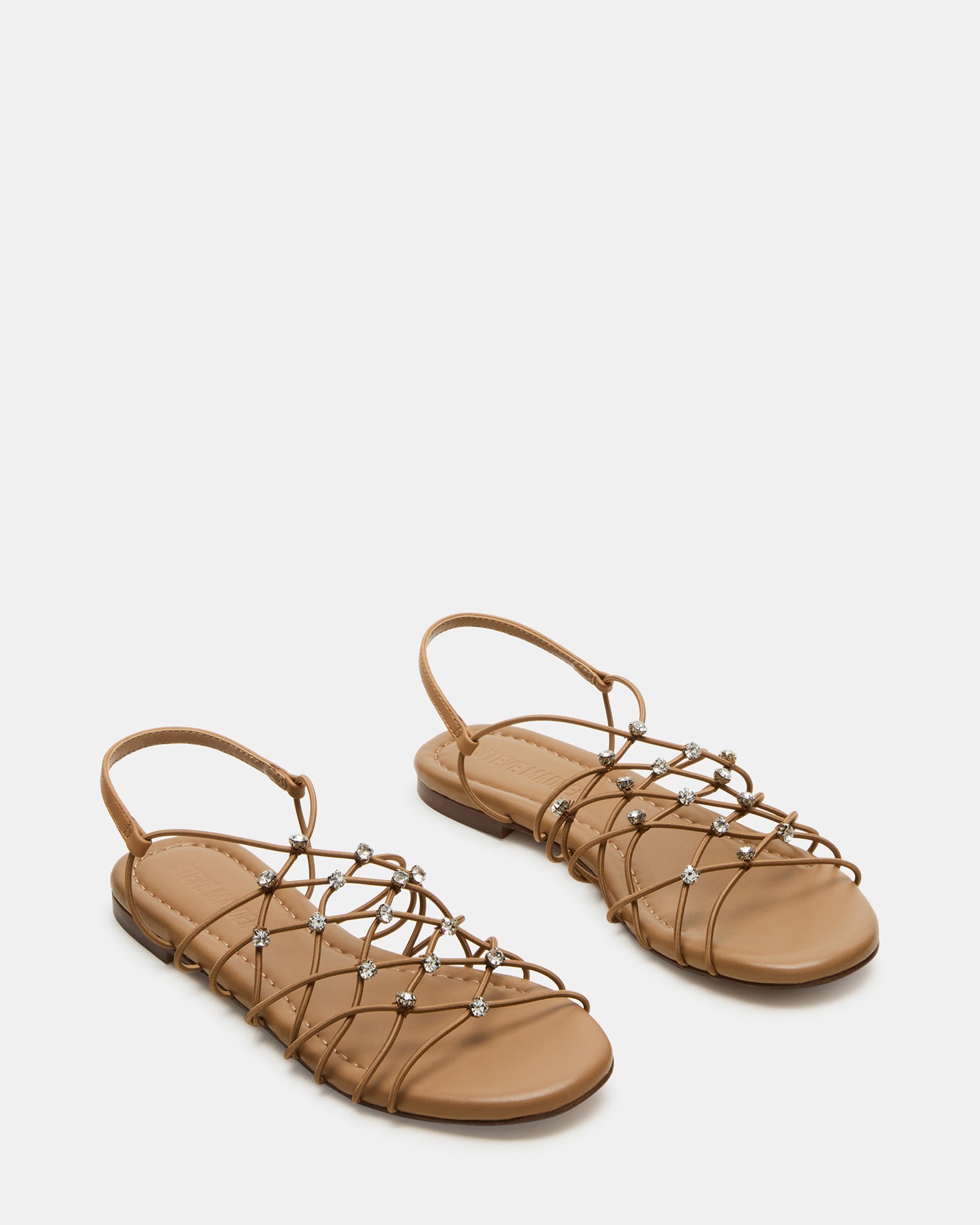 Side view of black flat sandals with foot modeling angle