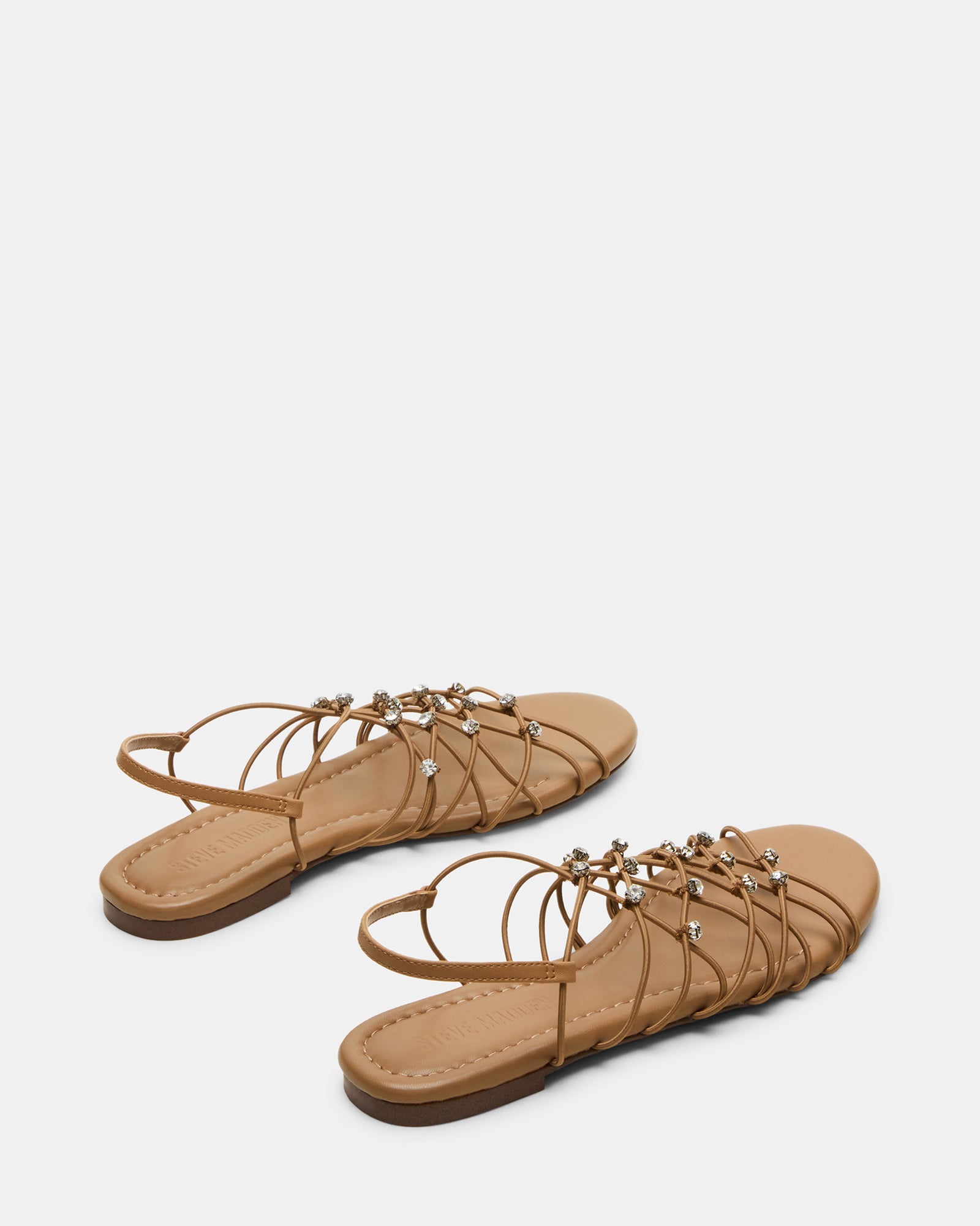 Side view of black flat sandals with foot modeling angle