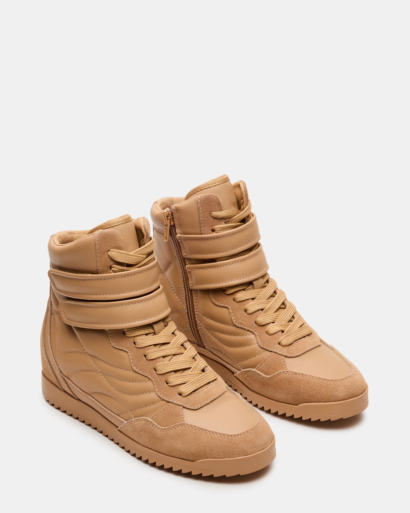 Close-up of lace-up detailing on tan leather sneakers