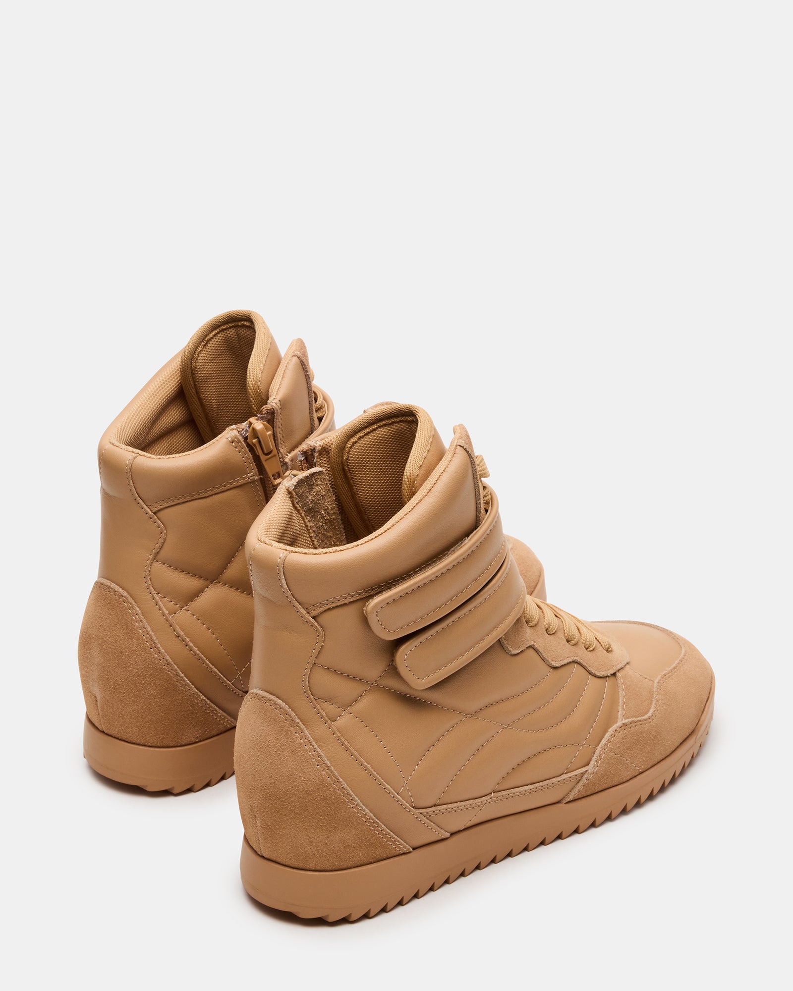 Close-up of lace-up detailing on tan leather sneakers