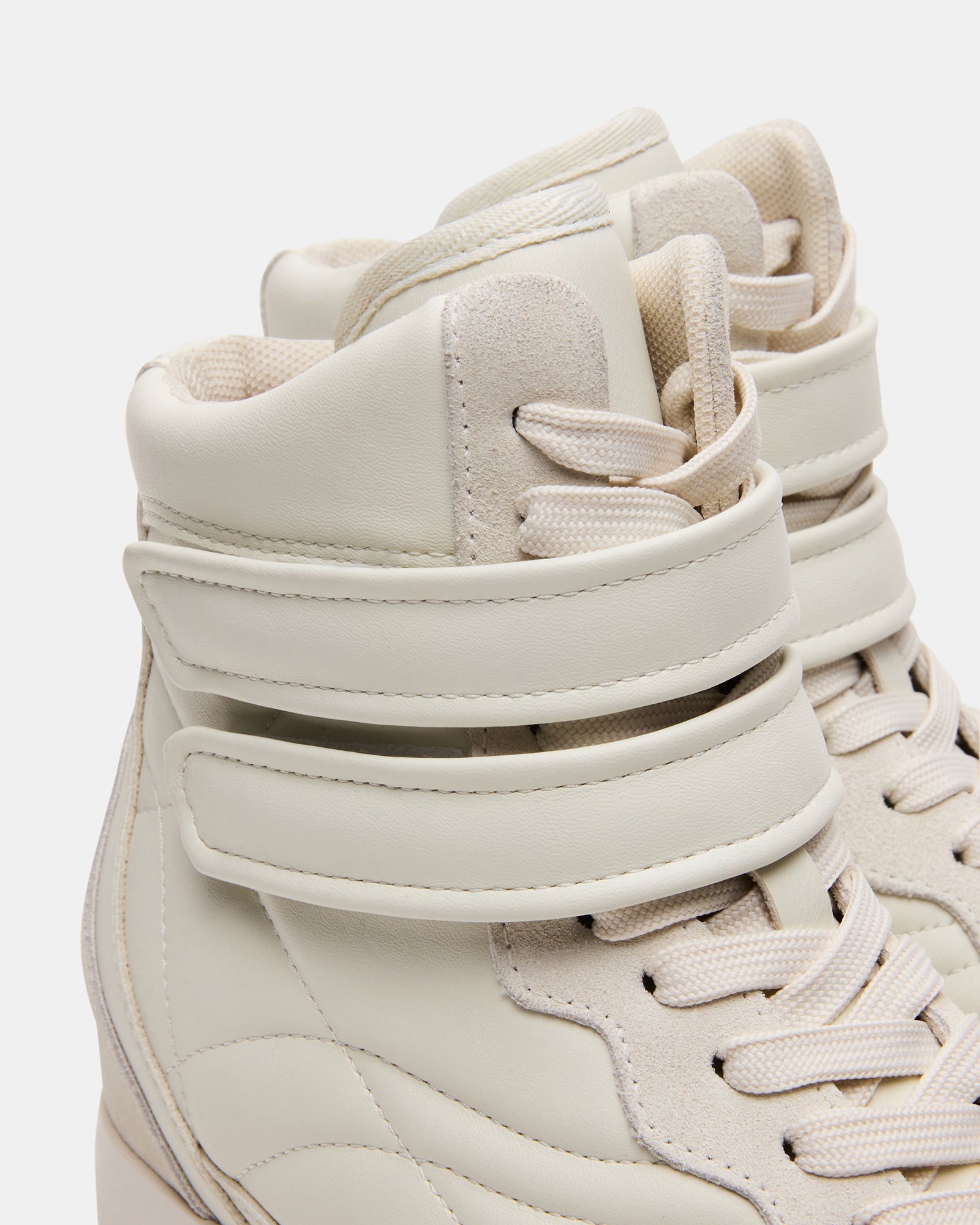 Stylish mens white leather tennis shoes on a city street.