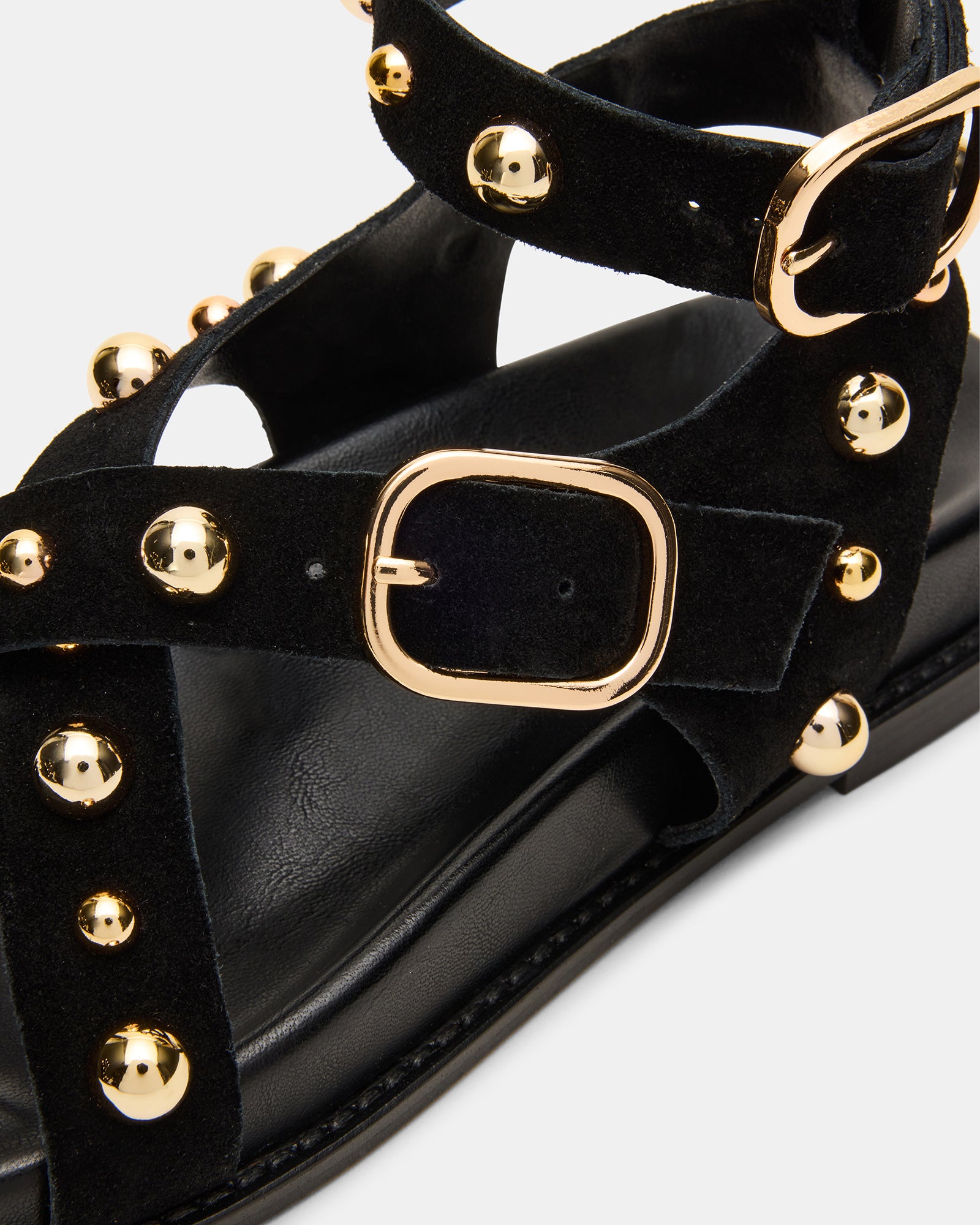 Close-up of black strappy sandals showcasing stud details.