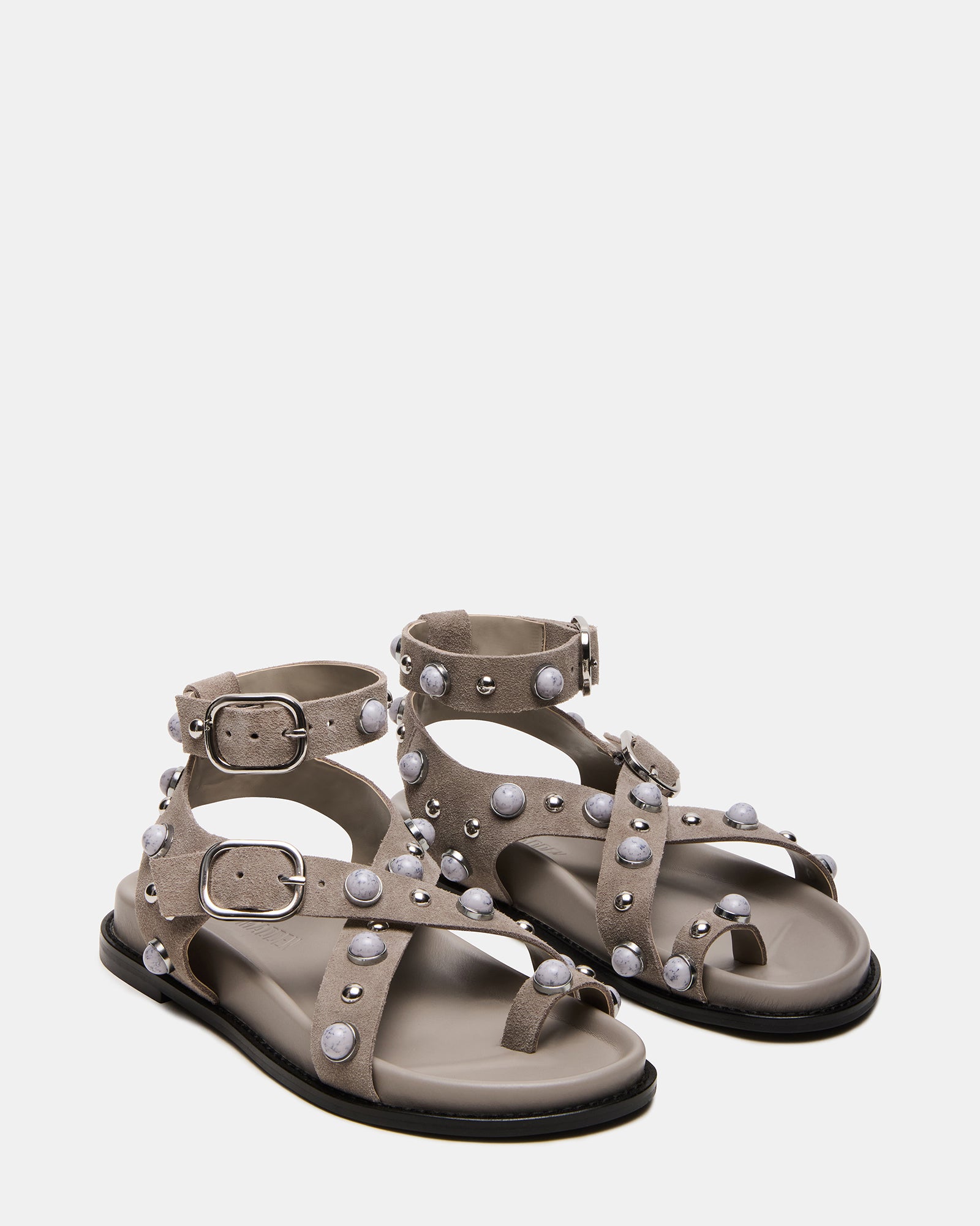 Model wearing comfortable sandals with ankle strap on a sunny beach.