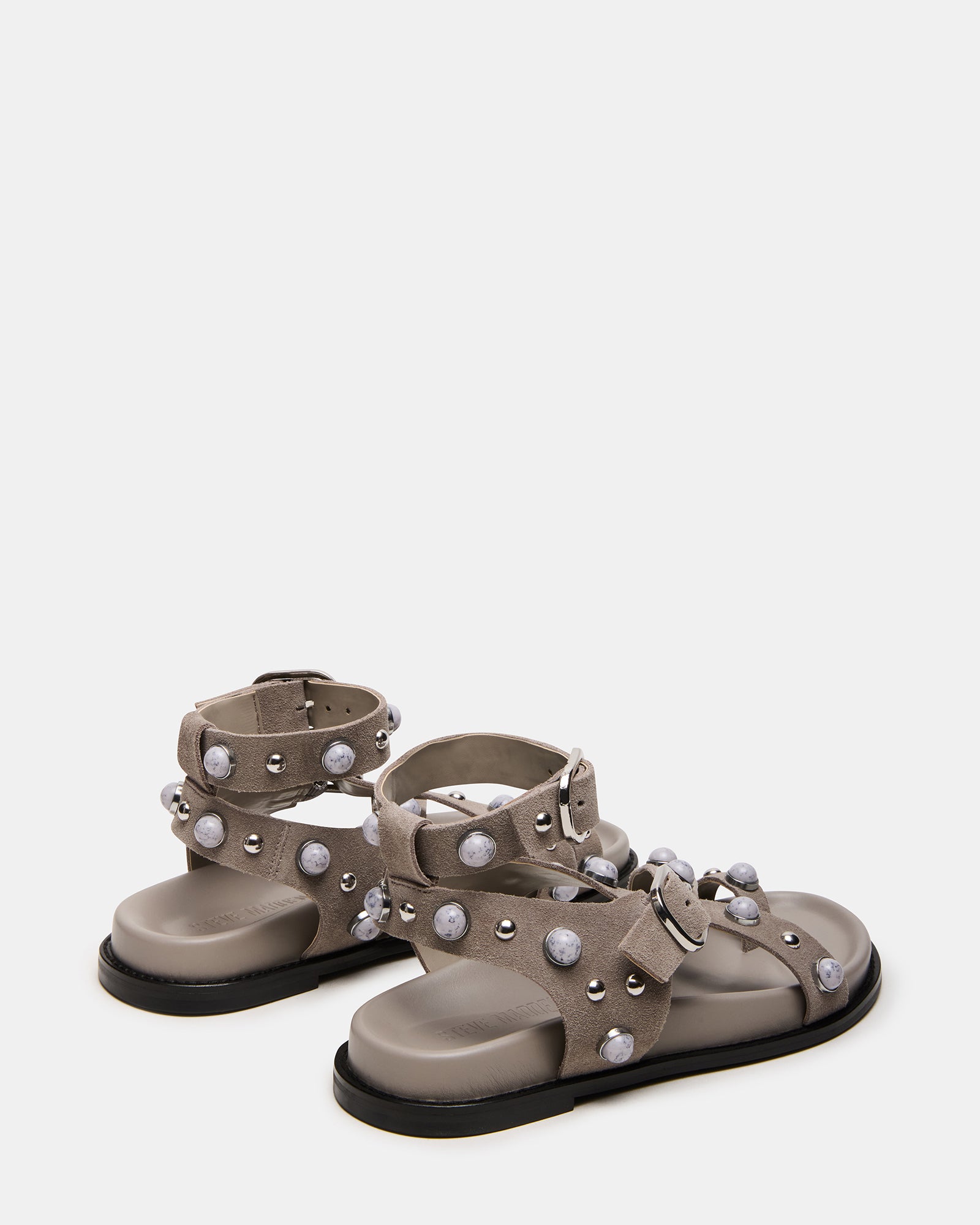 Model wearing comfortable sandals with ankle strap on a sunny beach.