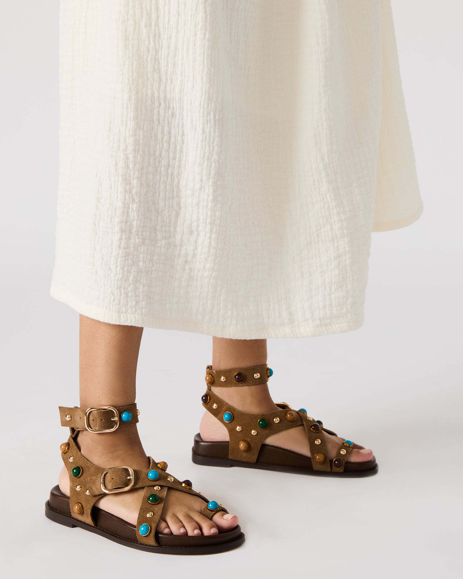 Close-up of the stud hardware on taupe suede sandals, highlighting their stylish design.