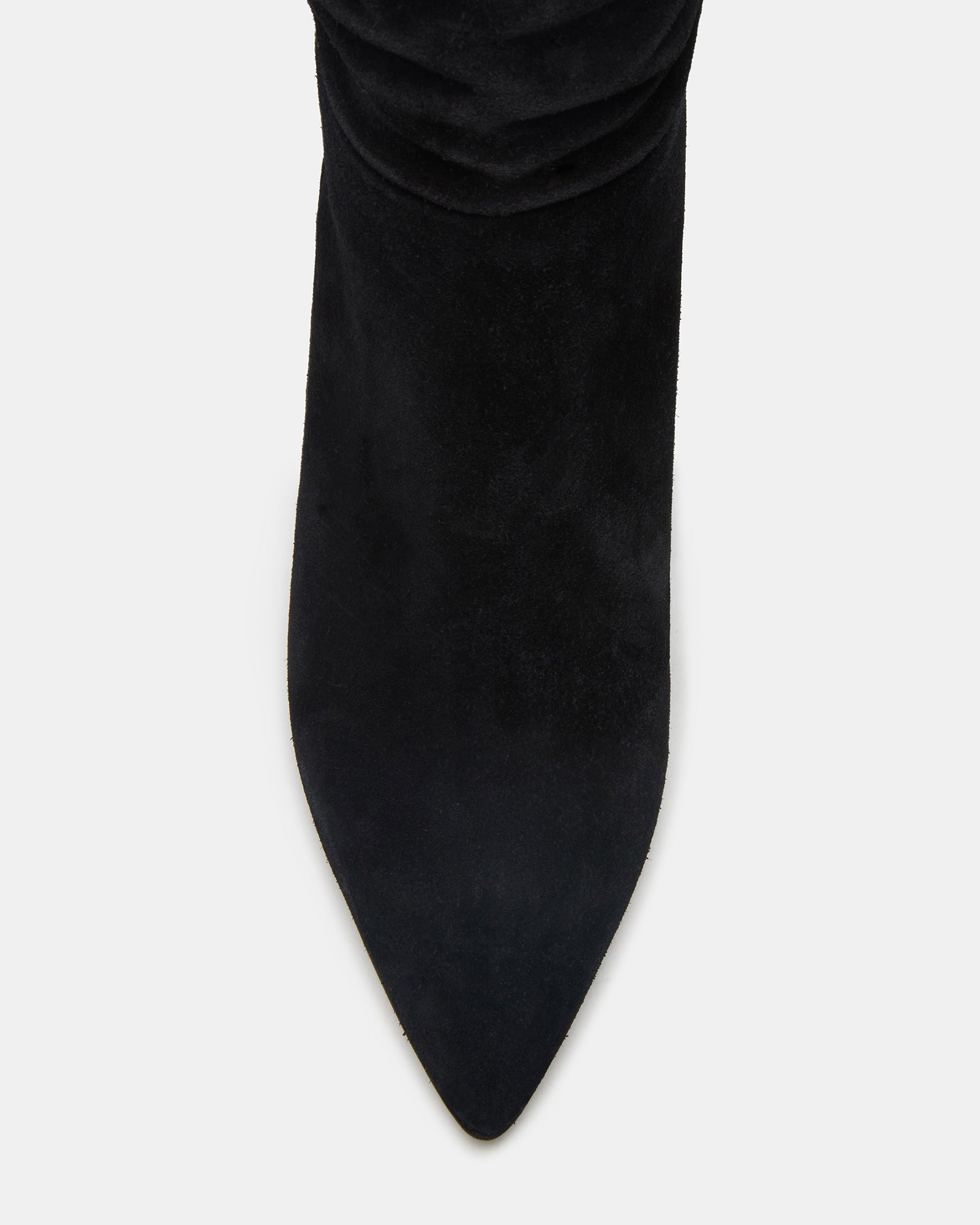 Side view of pointed toe black suede boots worn with a dress.