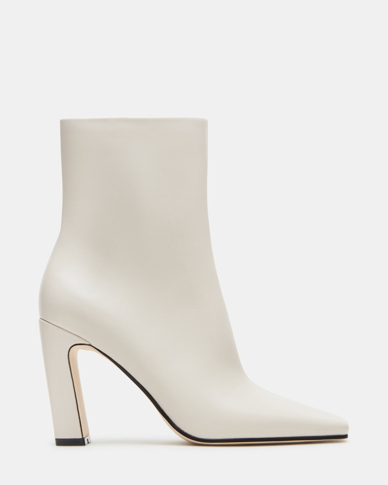 Side view of luxurious bone leather chelsea booties on a wooden floor.
