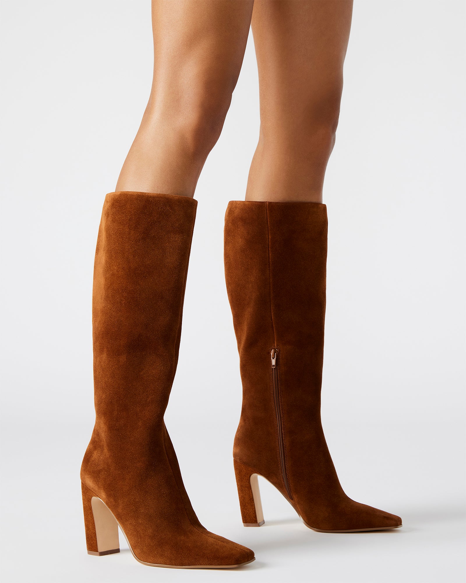 Fashionable knee-high boots in cognac suede paired with jeans for a casual look