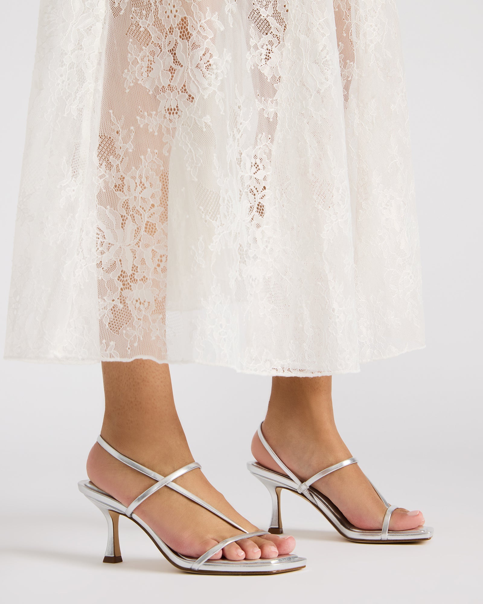 Close-up of vegan leather strappy detailing on white heels
