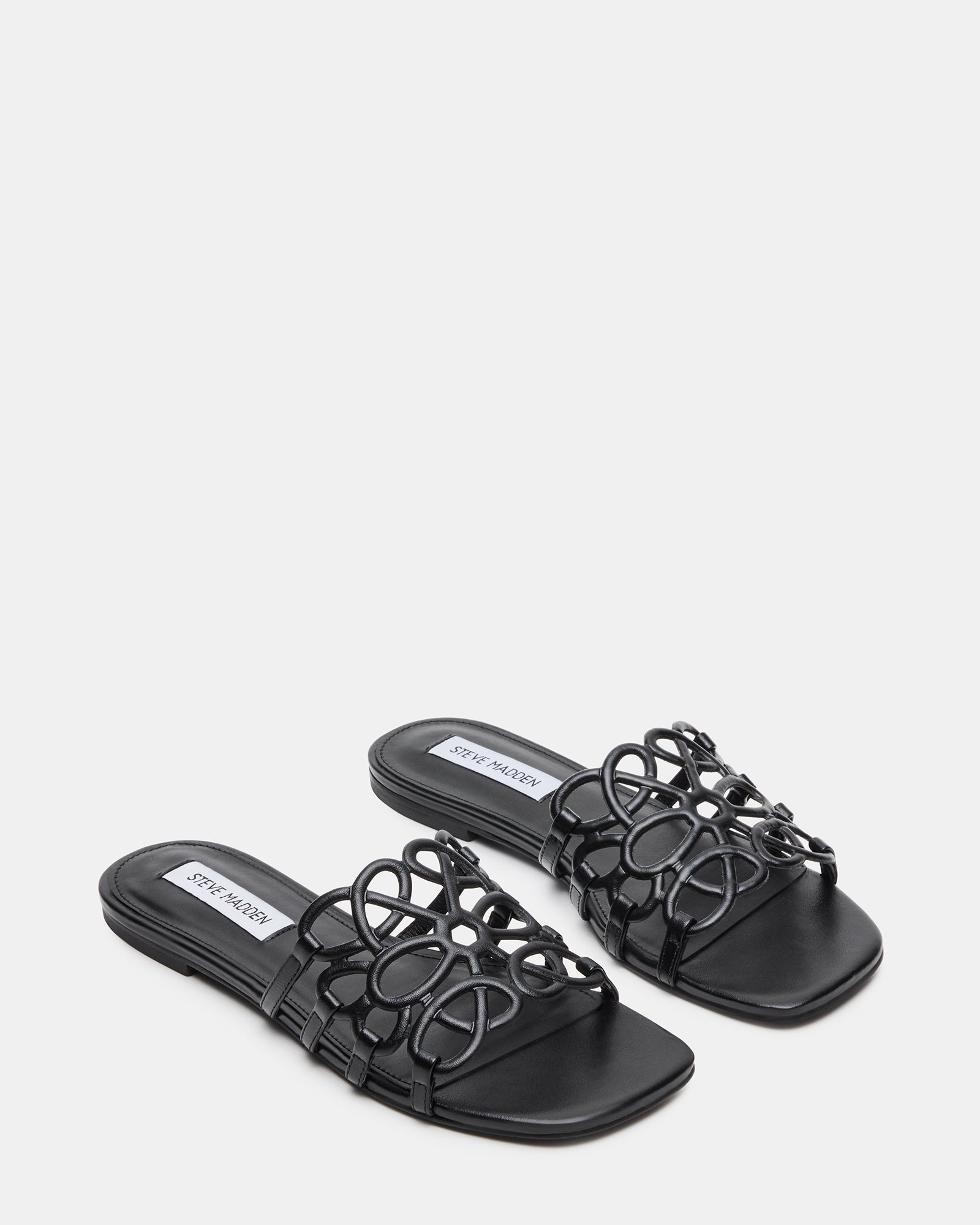 Side profile of black leather platform sandals on pavement