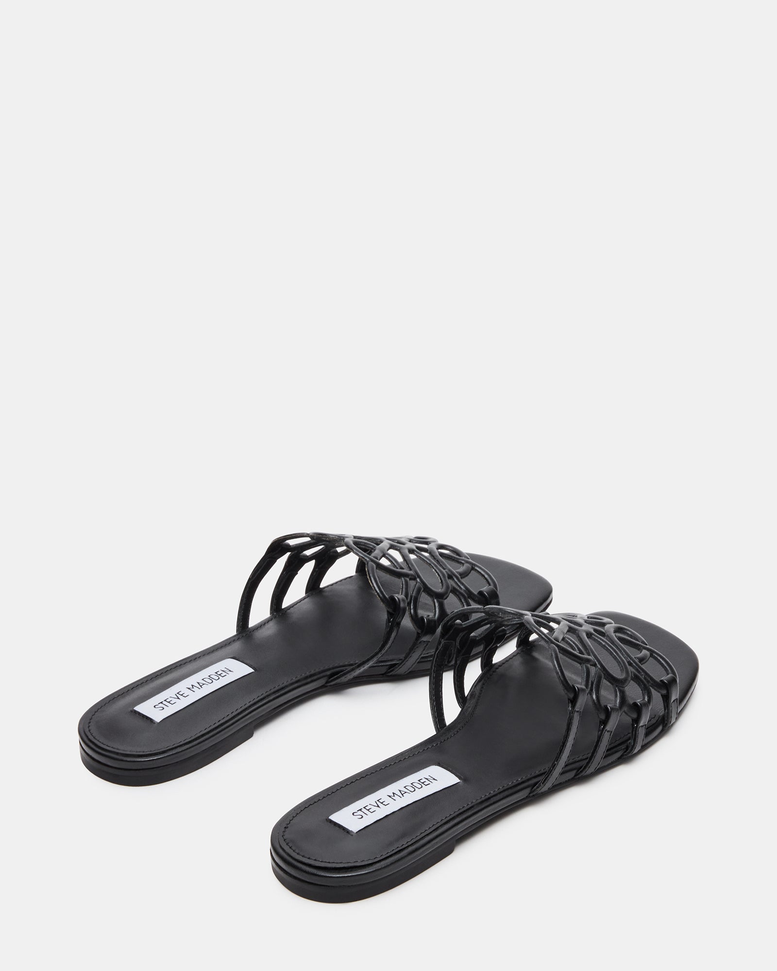 Side profile of black leather platform sandals on pavement