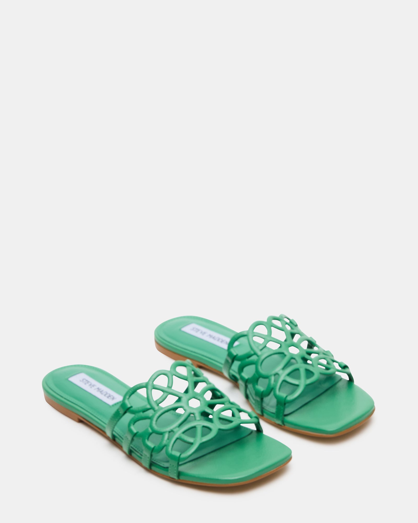 Side profile of black leather slide sandals on patio floor