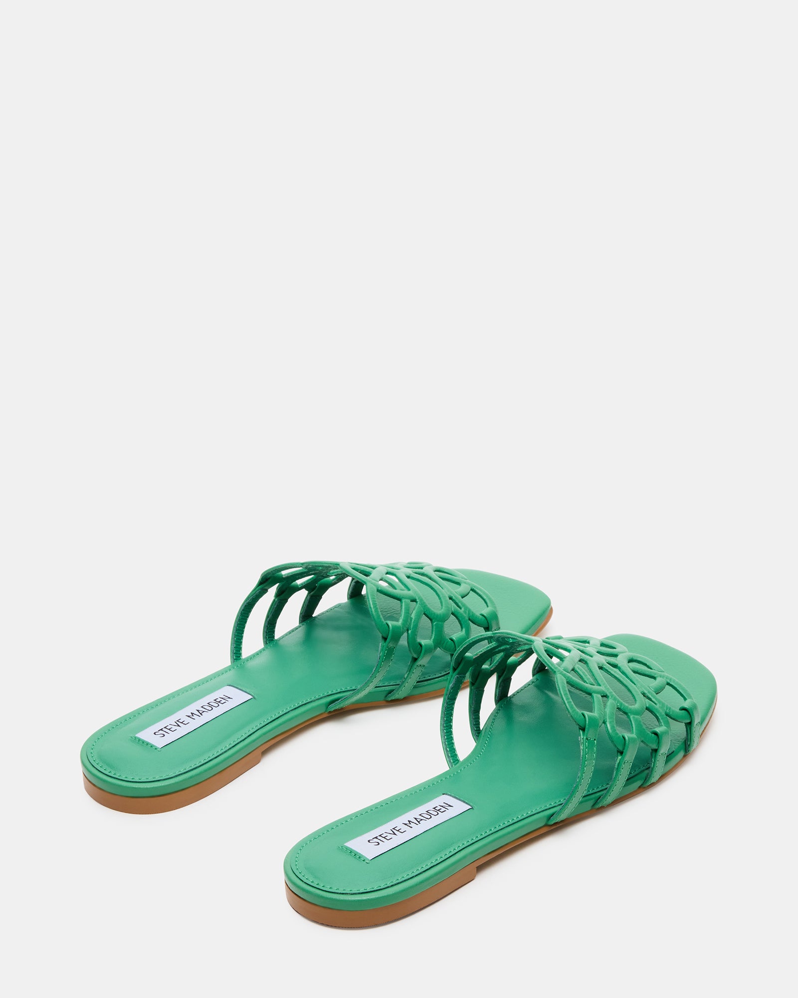 Side profile of black leather slide sandals on patio floor