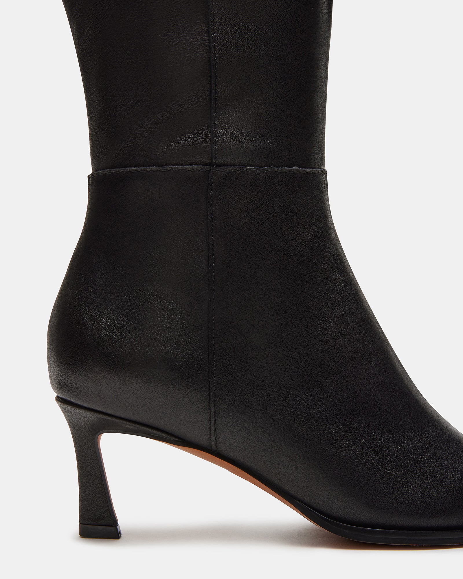 Side view of LUCID black leather knee high boots with kitten heel.