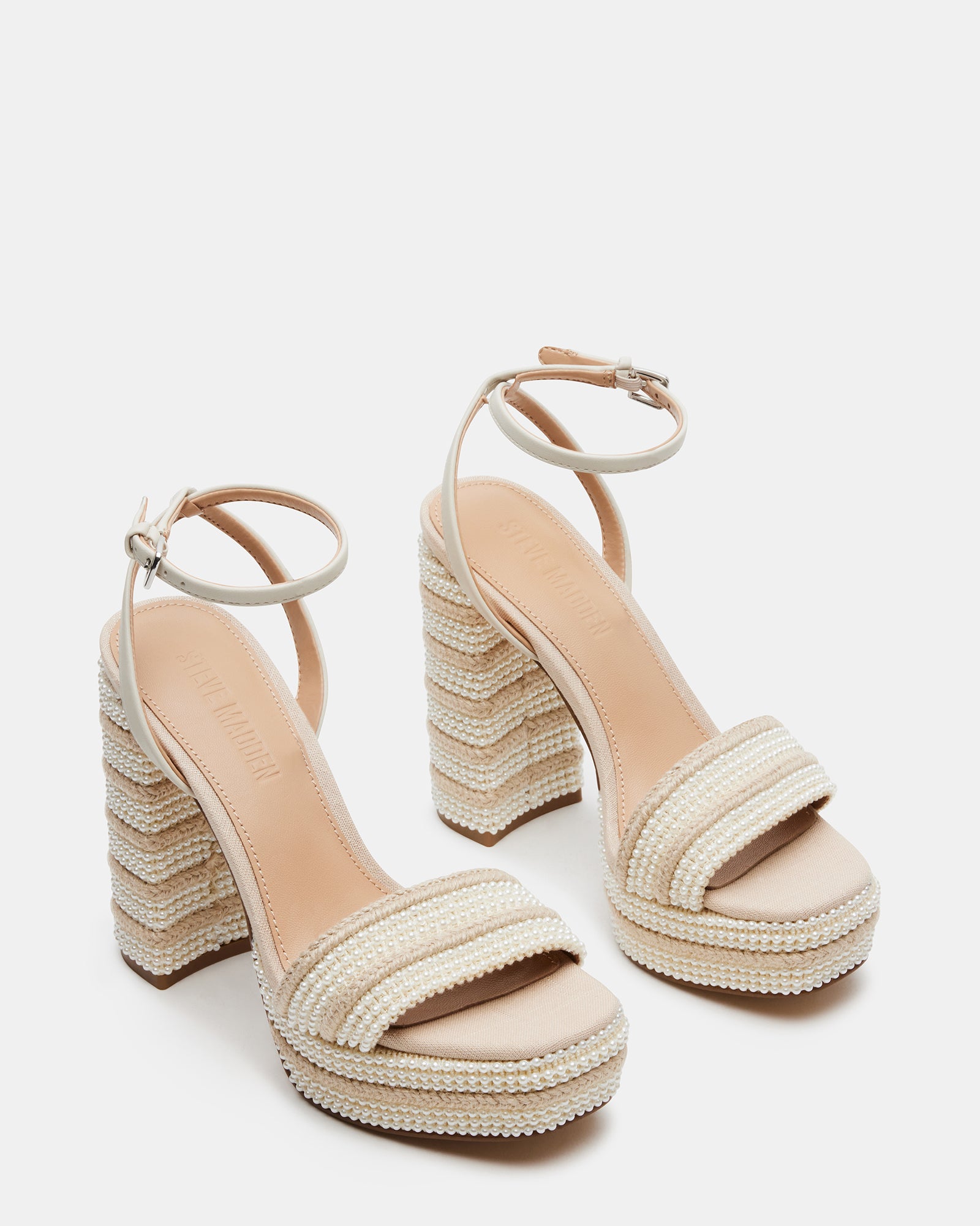 Model wearing raffia heeled sandals at a seaside wedding