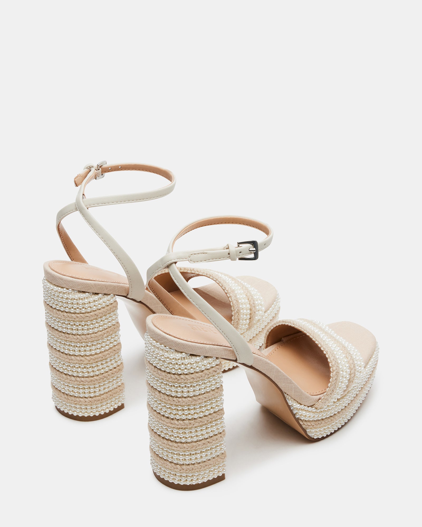 Model wearing raffia heeled sandals at a seaside wedding