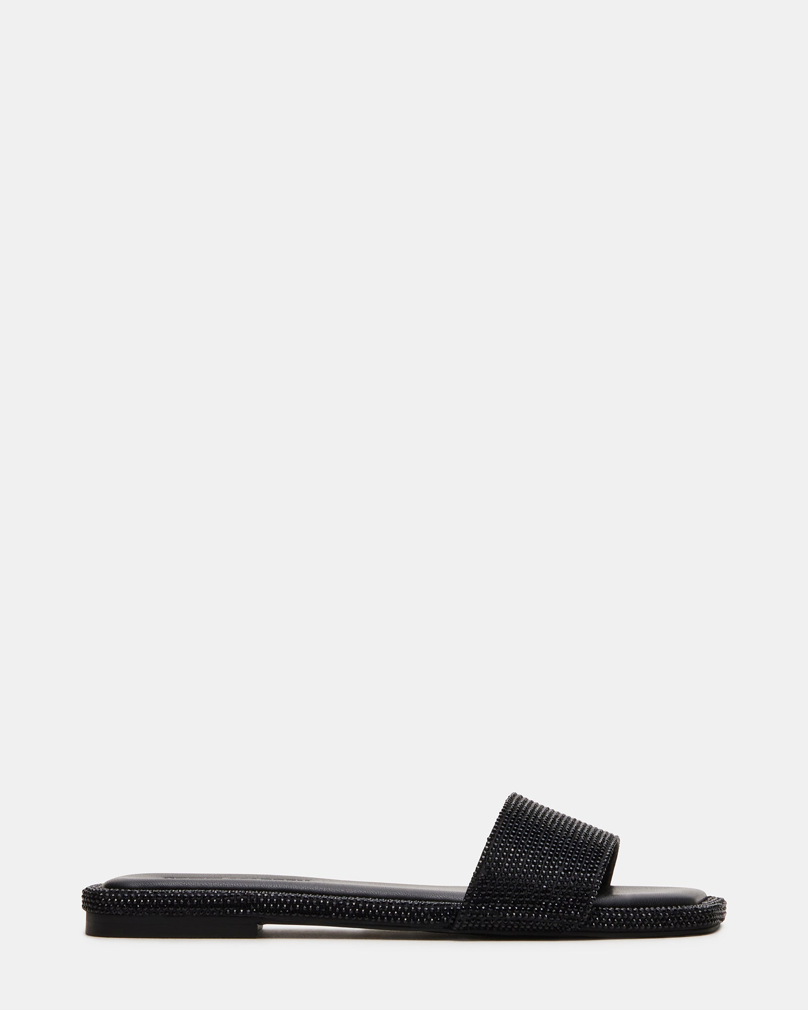 LUMINA black rhinestone slide sandals in a stylish outdoor setting.