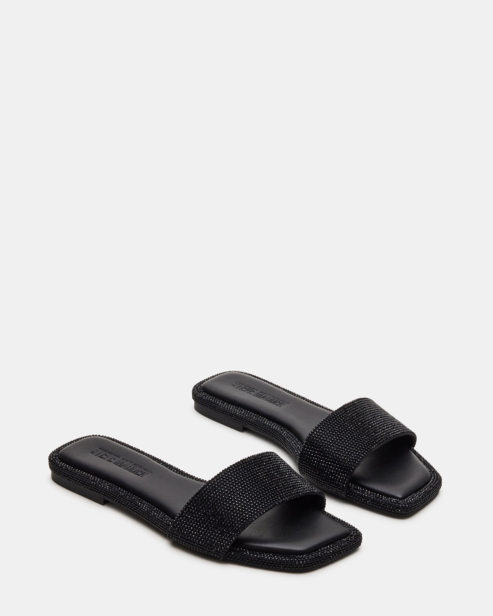 Close-up of square toe flat sandals adorned with rhinestones.