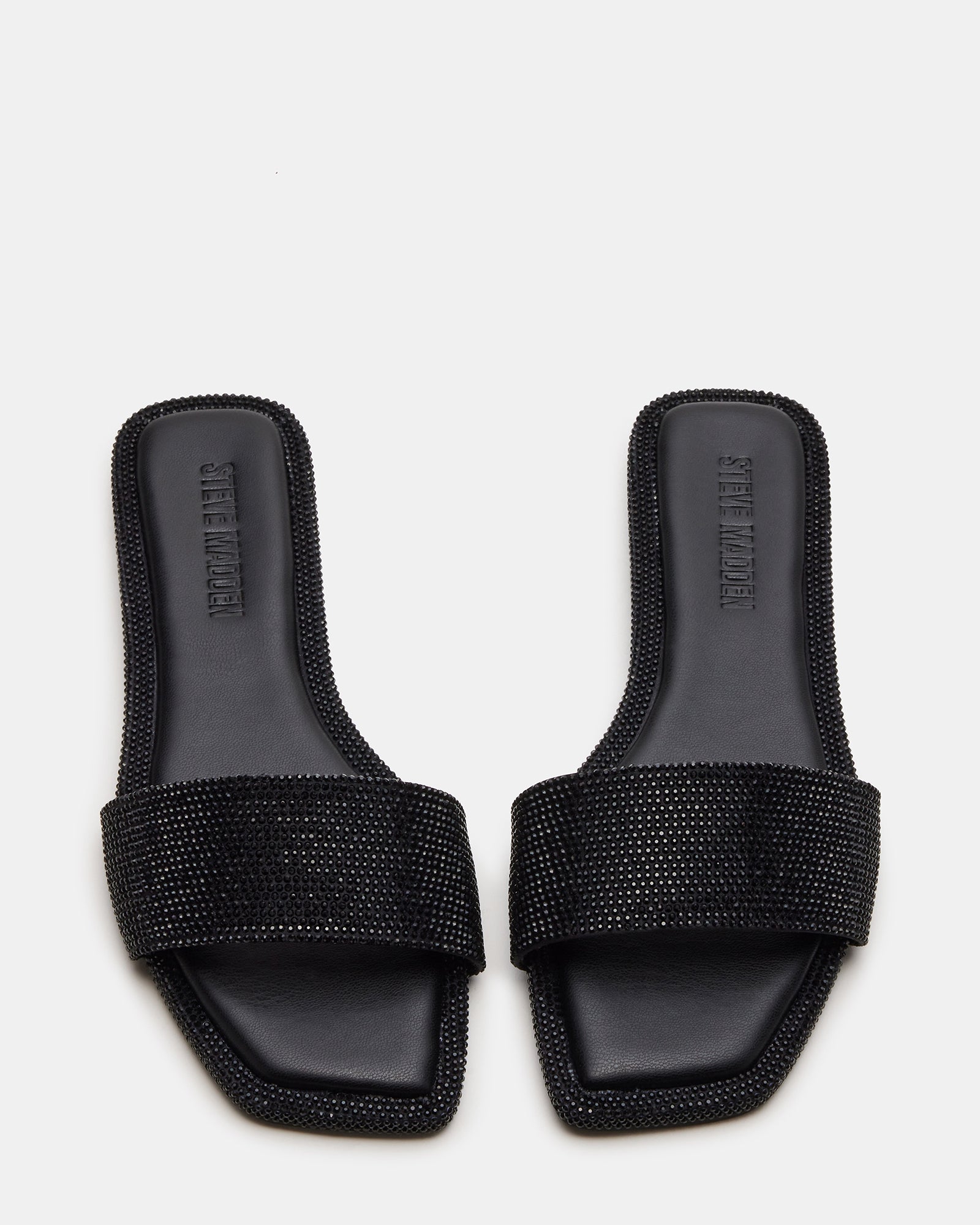LUMINA black rhinestone slide sandals in a stylish outdoor setting.