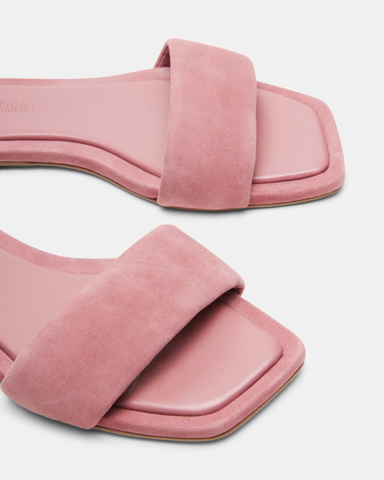 Pink suede slide sandals with square toe on a neutral background, showcasing stylish comfort