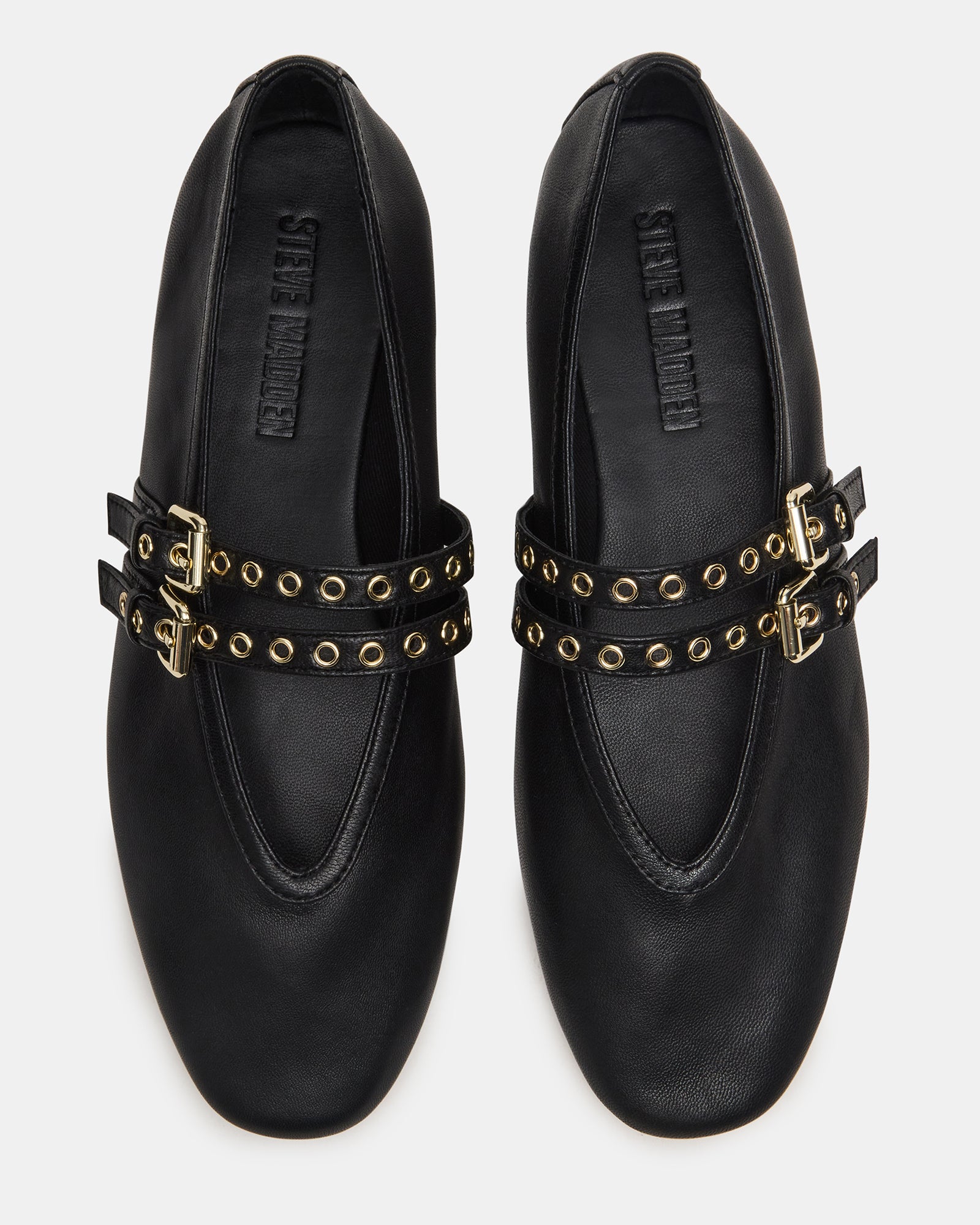 Side angle of black leather Mary Jane flats on hardwood floor
