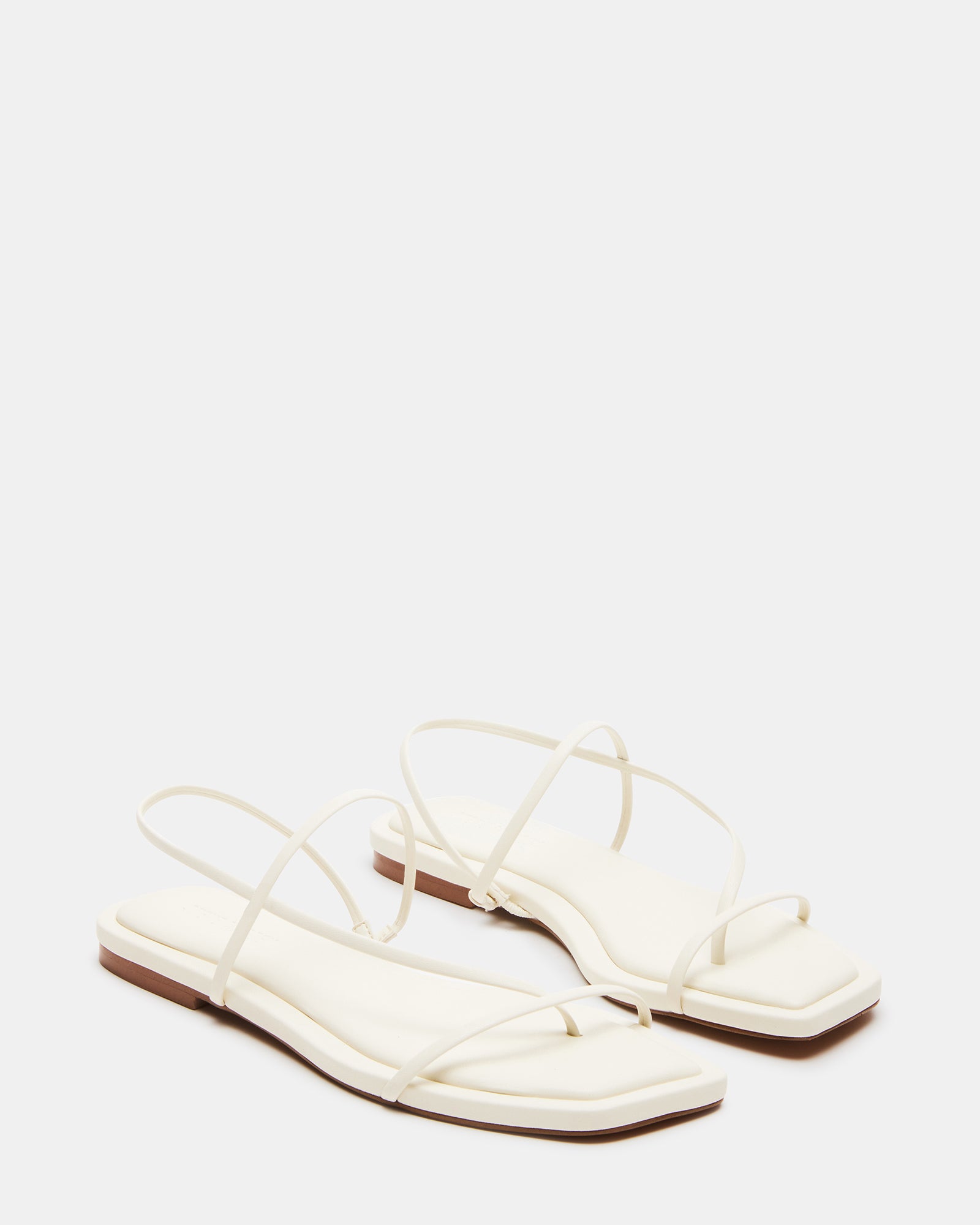 Close-up of Lynley White vegan shoes on a city sidewalk.