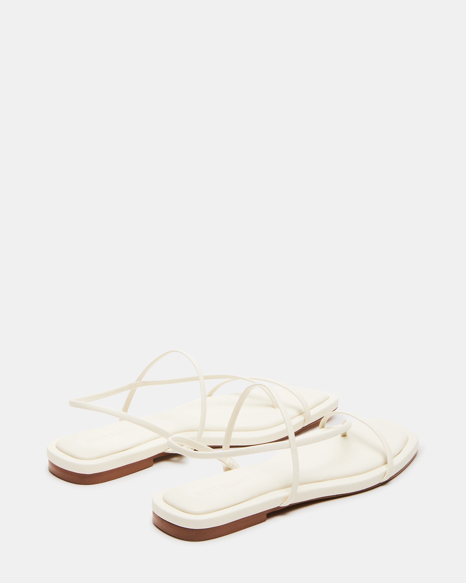 Close-up of Lynley White vegan shoes on a city sidewalk.