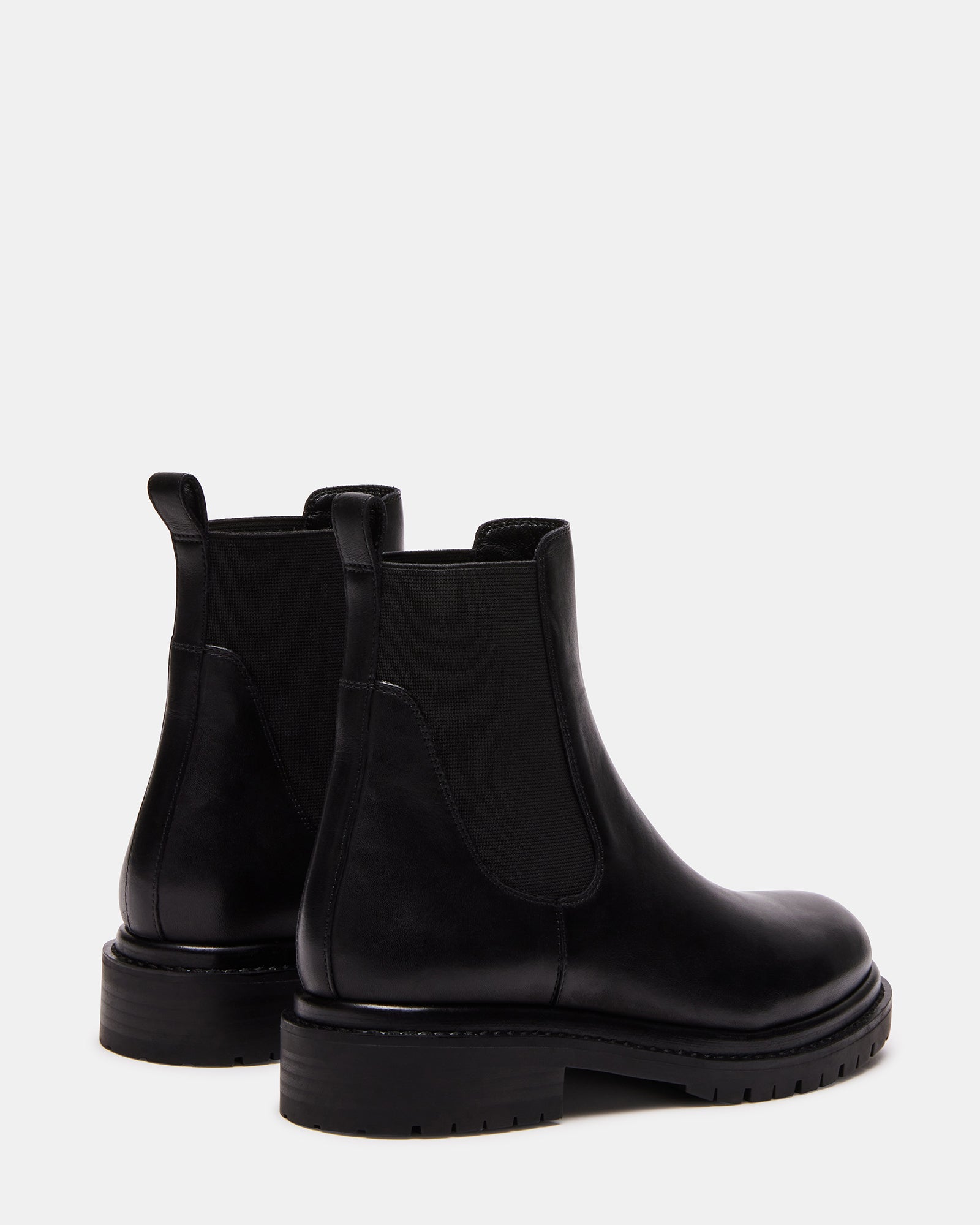 Side view of black leather Chelsea boot with treaded platform sole and pull loop