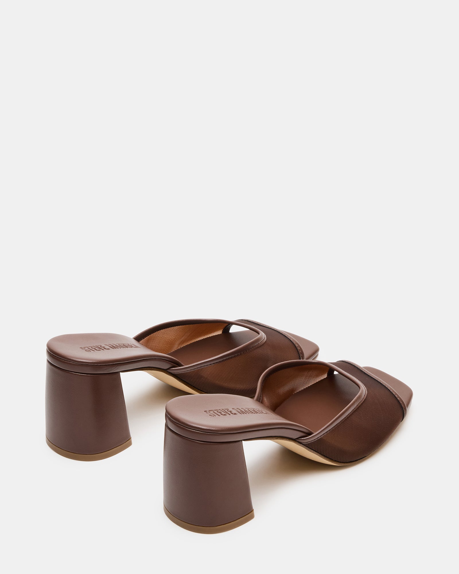 Styled shot of the block heel square toe pumps paired with light trousers outdoors