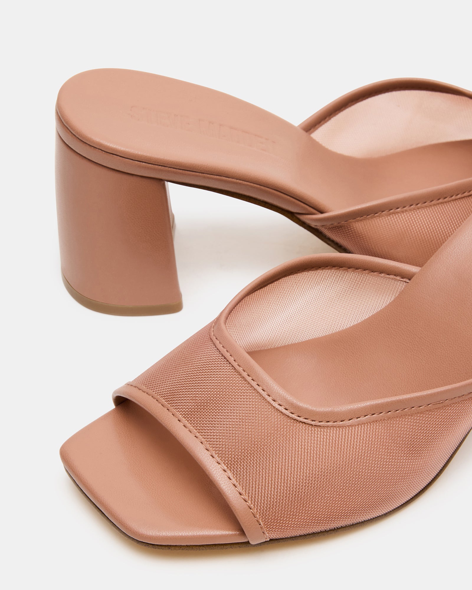 Model walking in comfortable heeled mules on downtown sidewalk