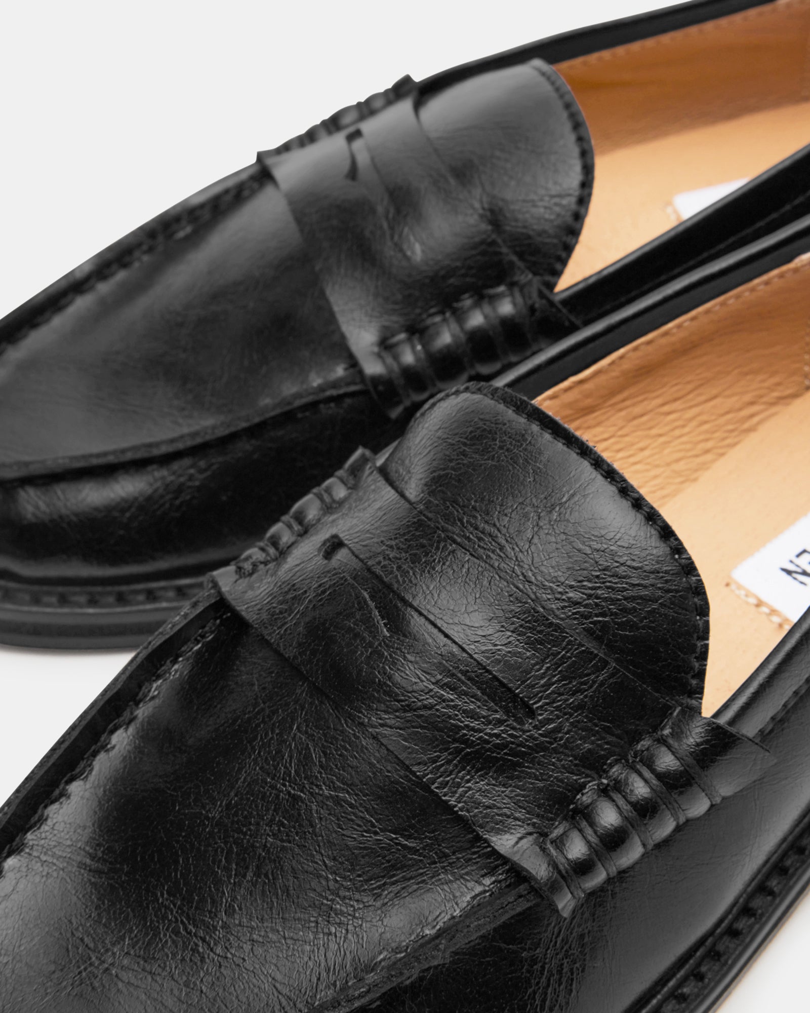 Madison black leather loafers side profile on hardwood floor
