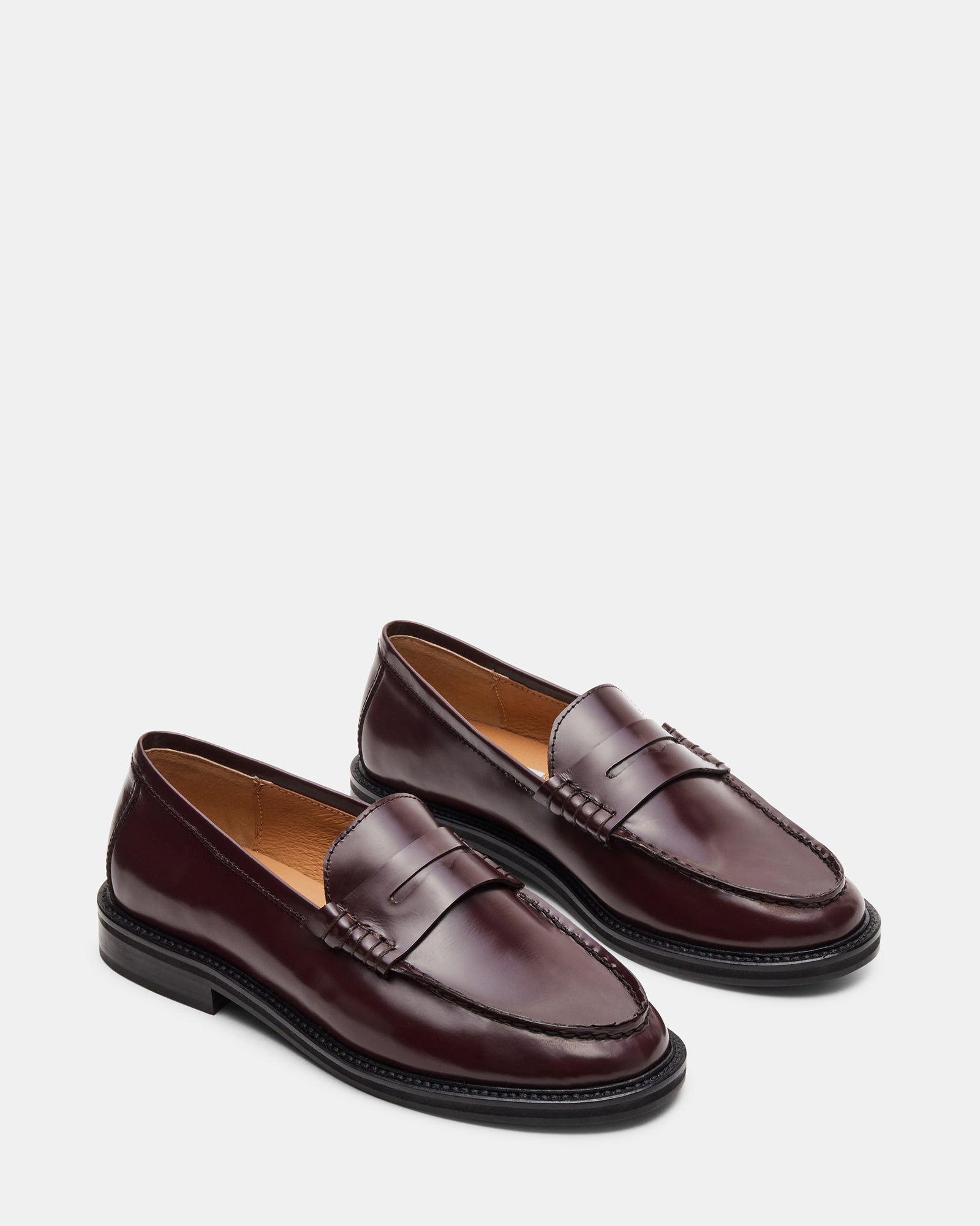 Top-down shot of black leather loafers paired with business casual attire