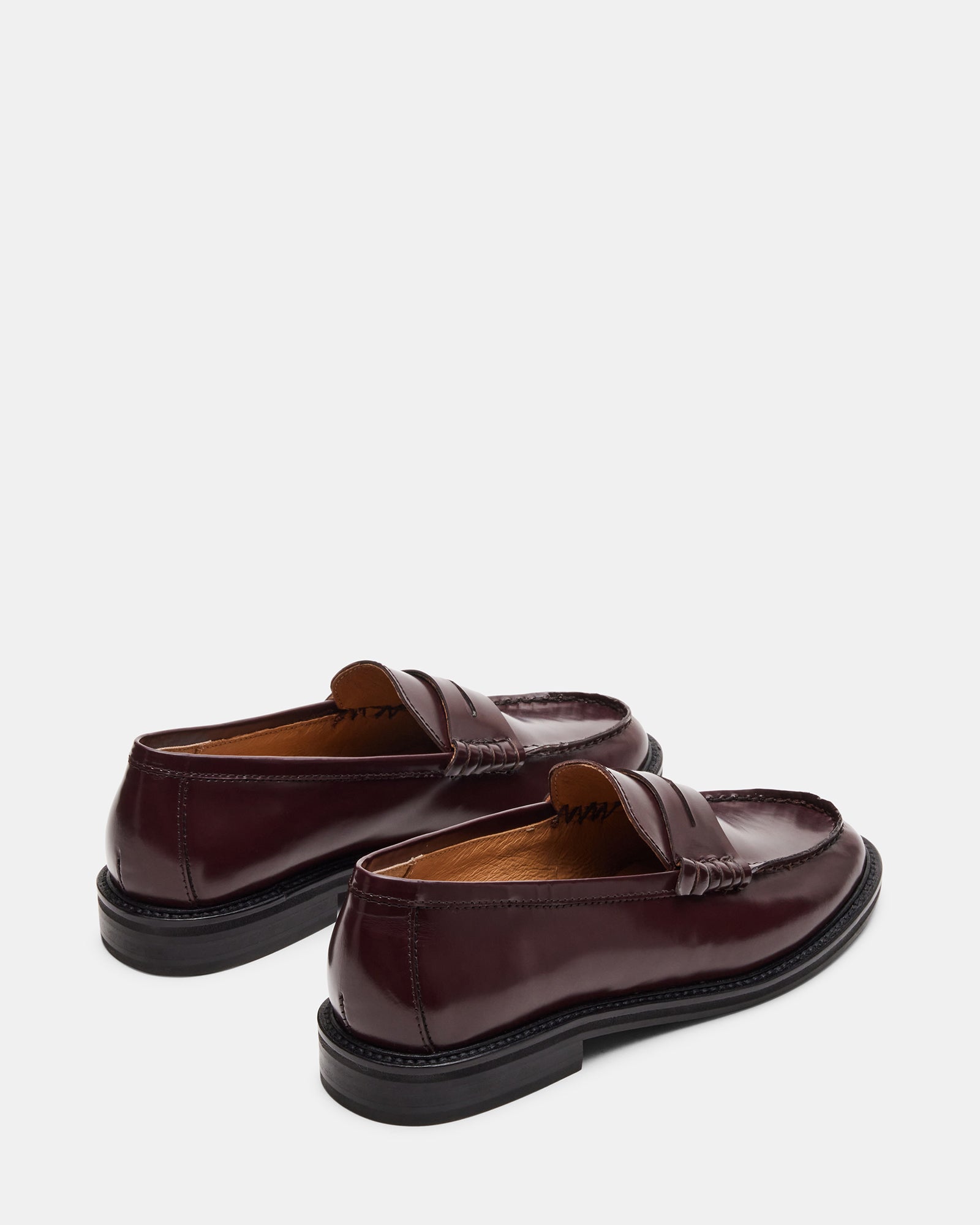 Top-down shot of black leather loafers paired with business casual attire