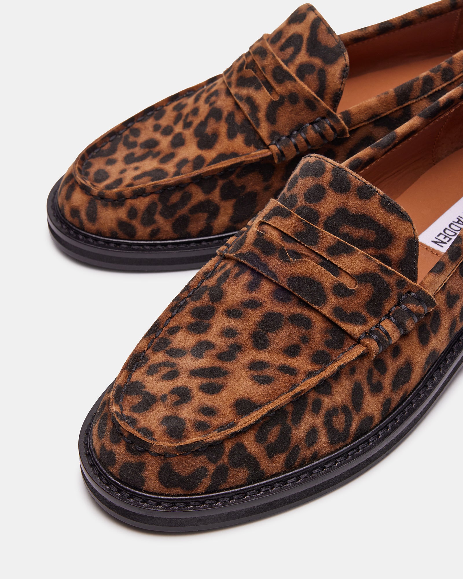 Overhead view of penny loafers paired with a travel duffel on NYC sidewalk