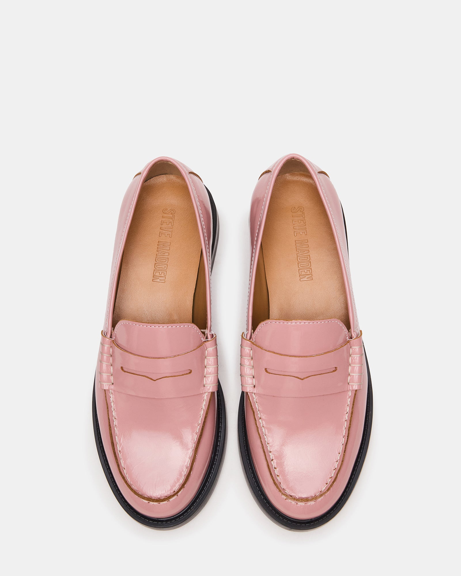 Elegant light pink leather loafers with a sleek design on a wooden surface