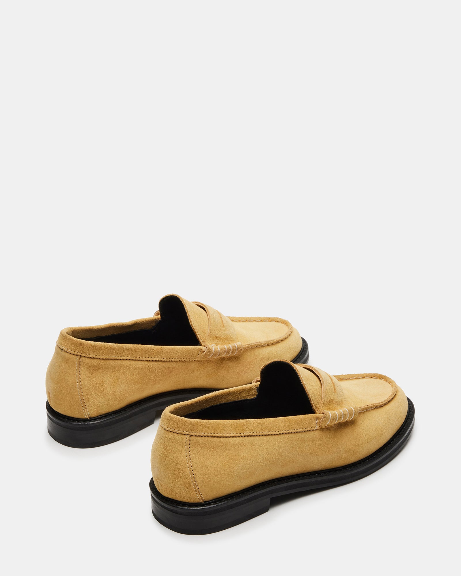 Side angle of mens shoes in yellow suede styled with tailored chinos