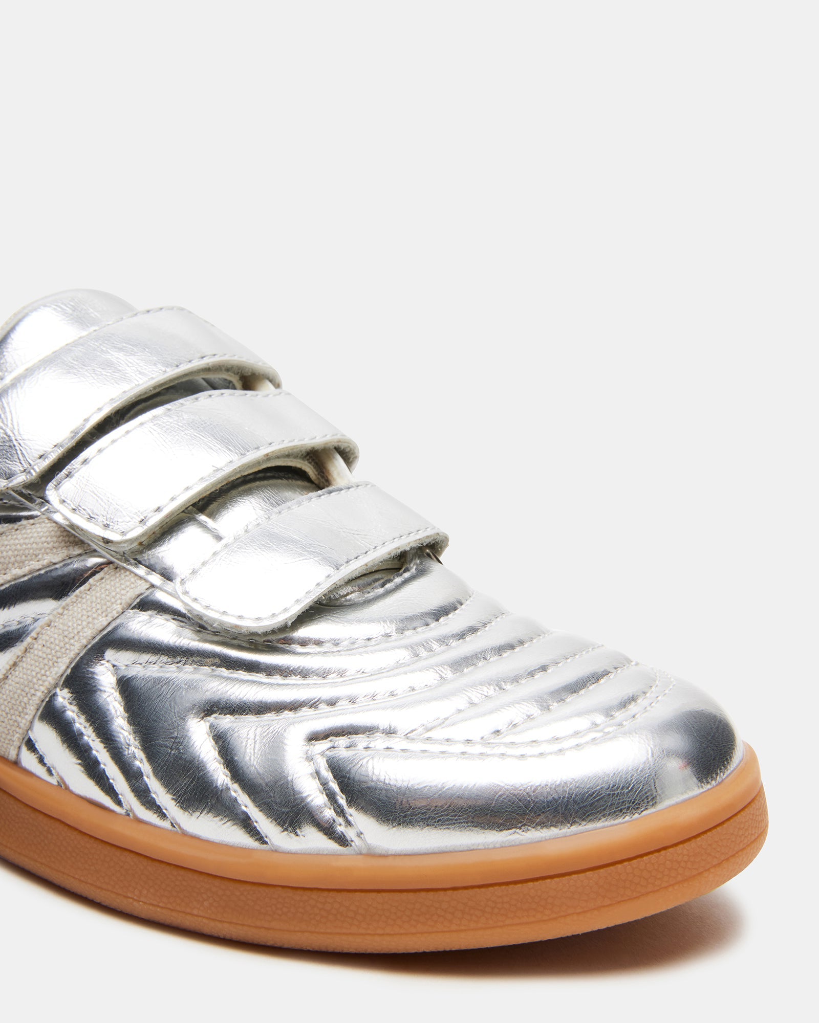 Magik Silver slip-on sneakers worn during an outdoor casual event.