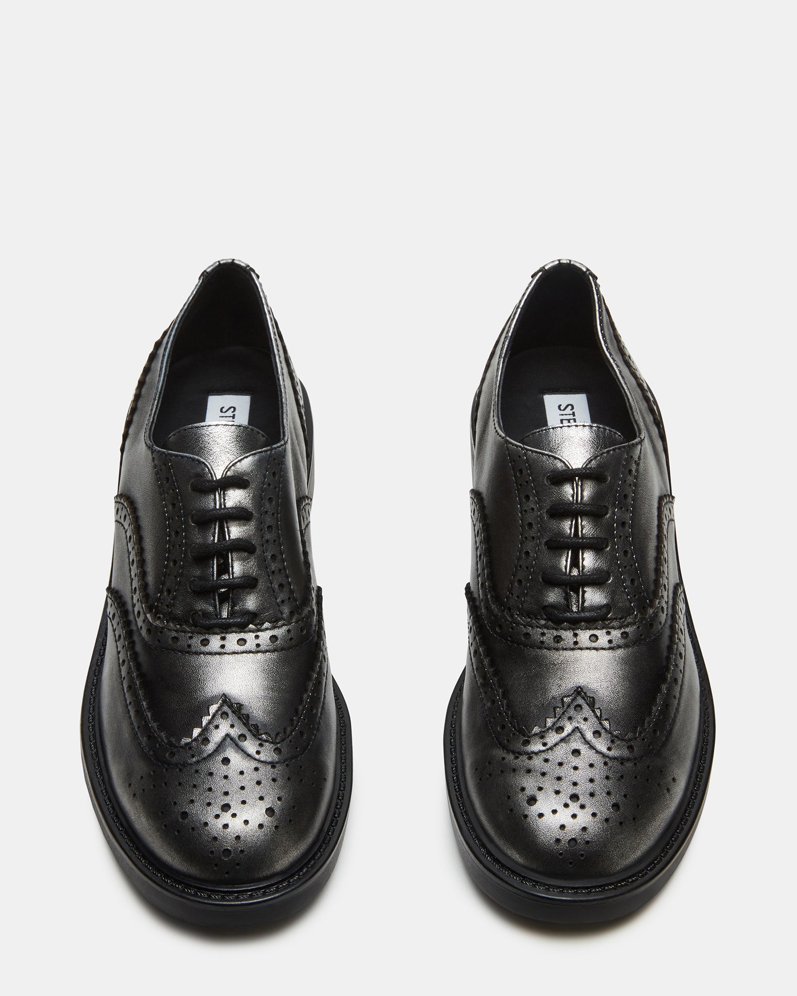 Side view of Malin silver leather loafers on a wooden floor.