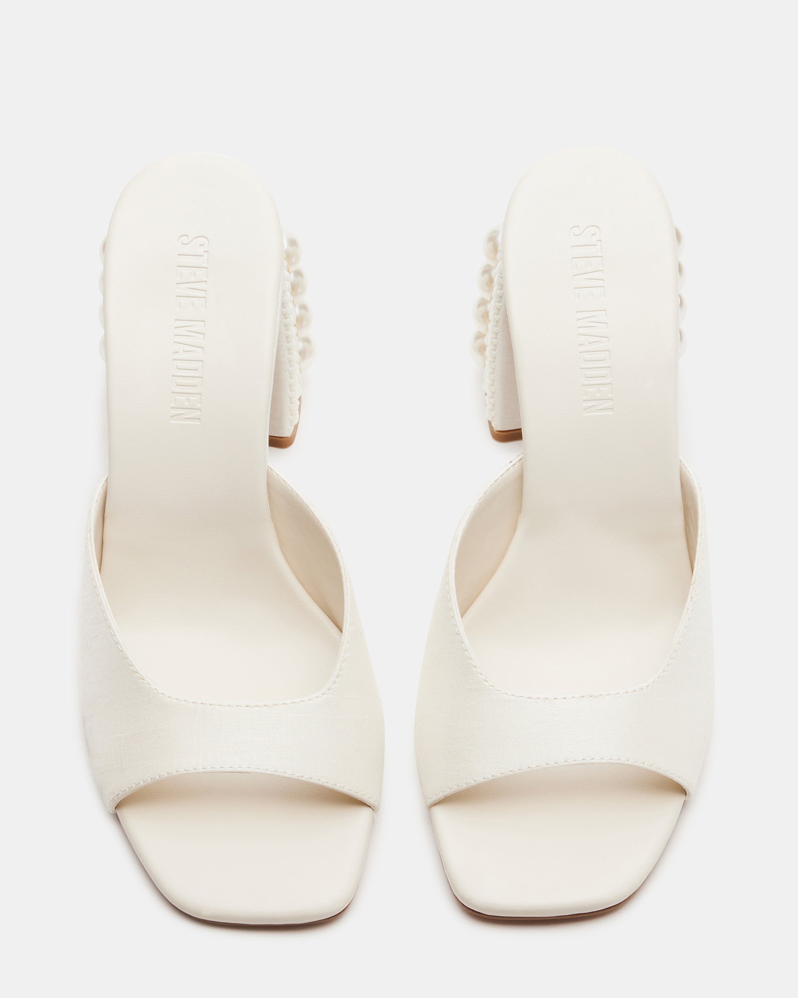 Side view of white mule heels showing square toe and block heel
