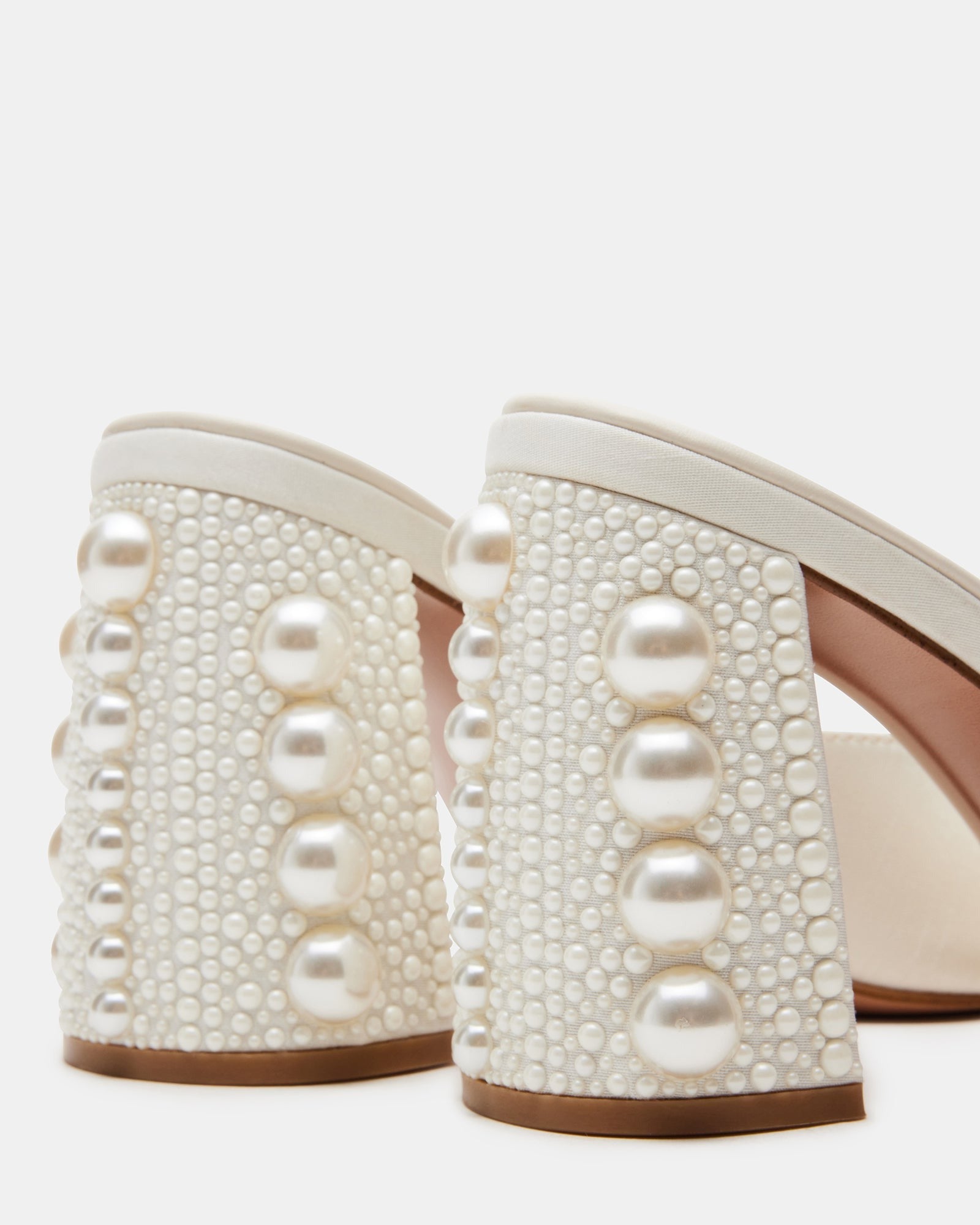 Close-up of black mule heels highlighting synthetic lining and sole