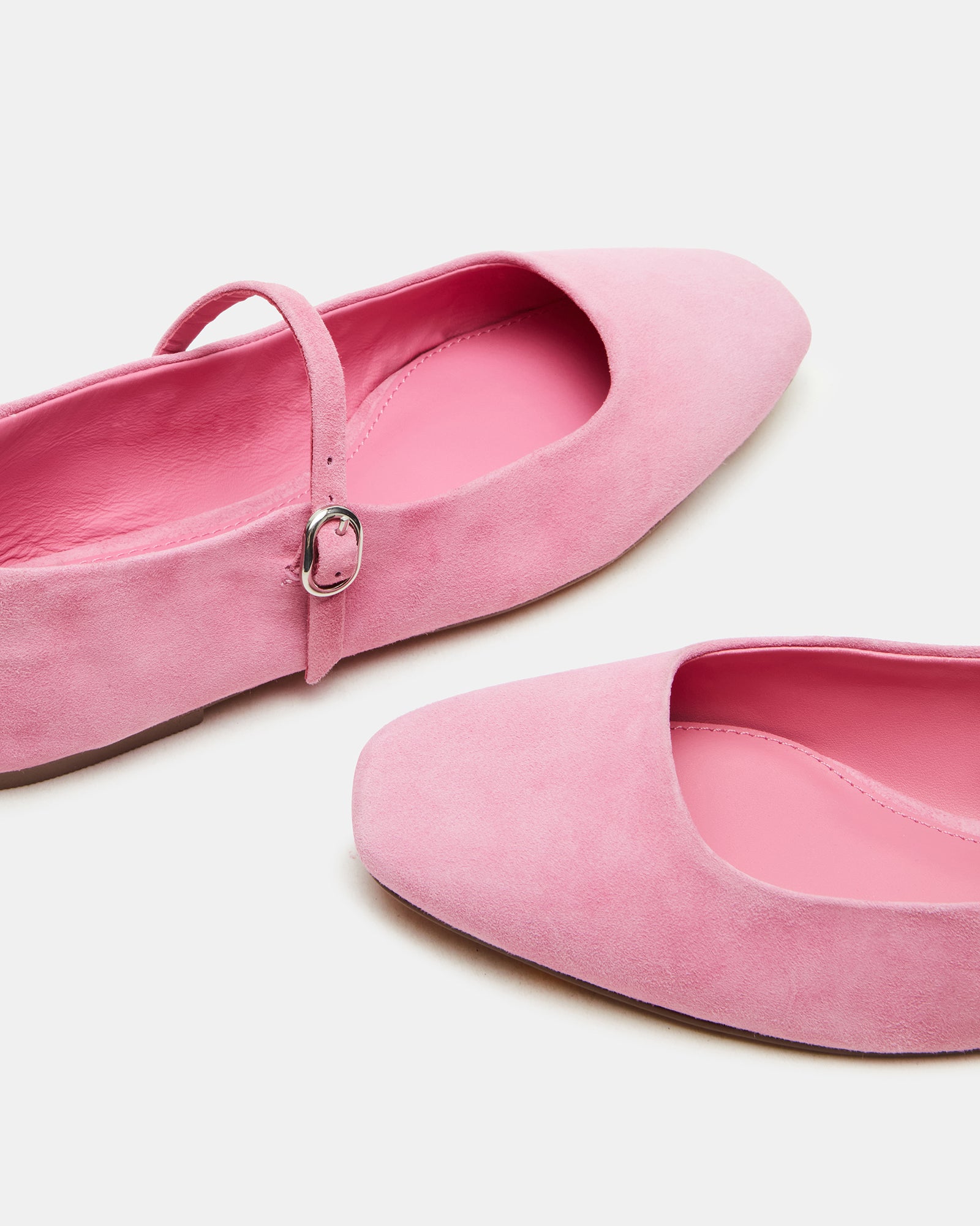Outdoor shot of suede flats worn with jeans on an urban sidewalk.