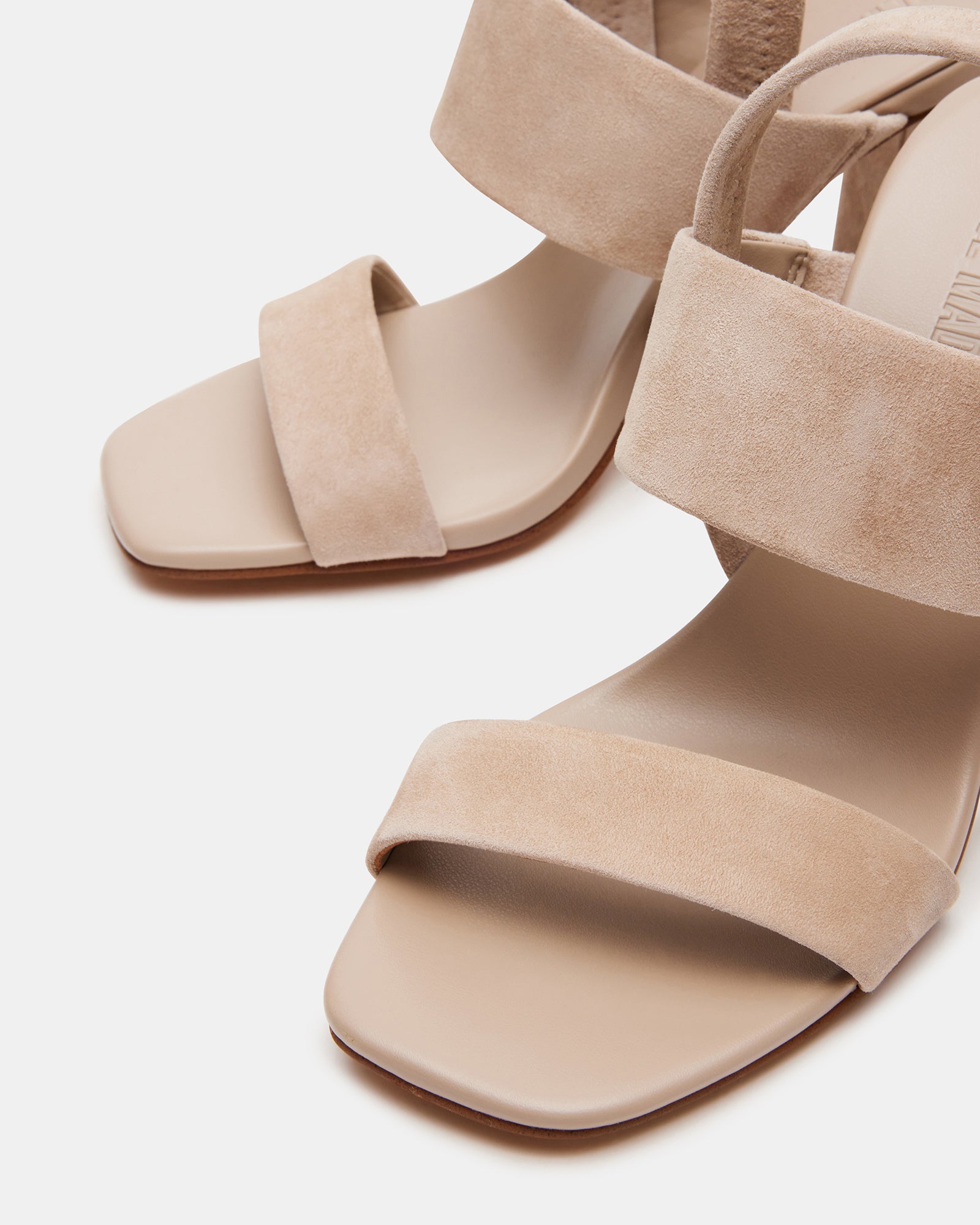 Top-down view of black block heels styled beside sunglasses and tote for city commuting