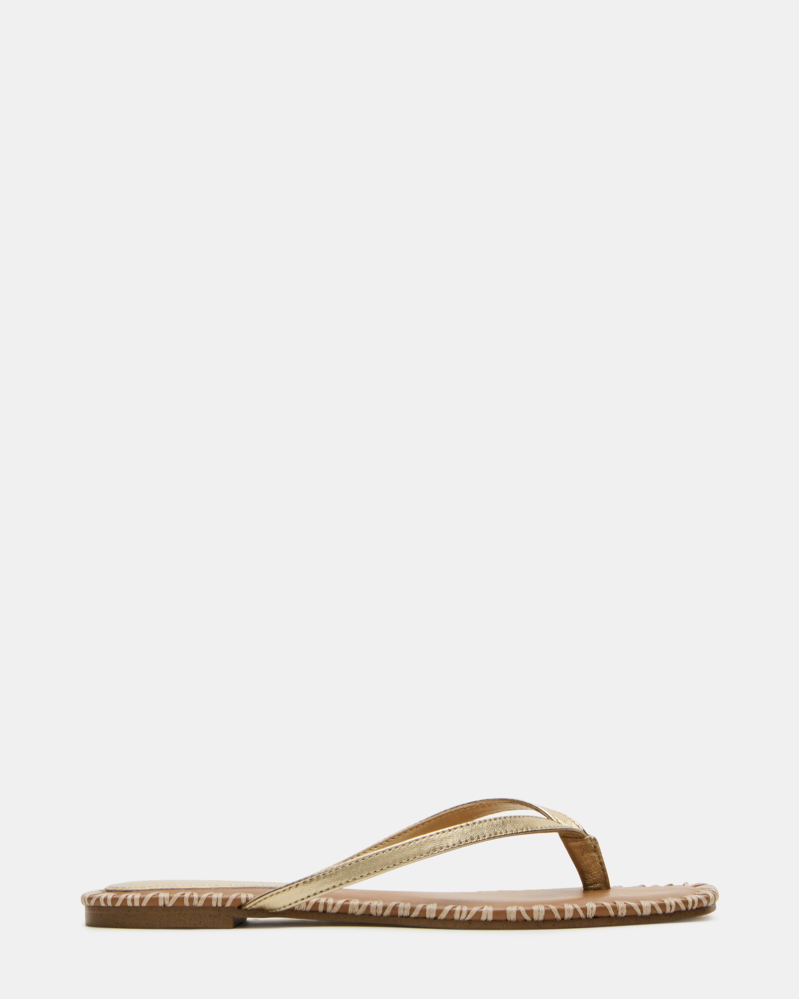 Gold leather square toe sandals with thong strap on a model’s feet