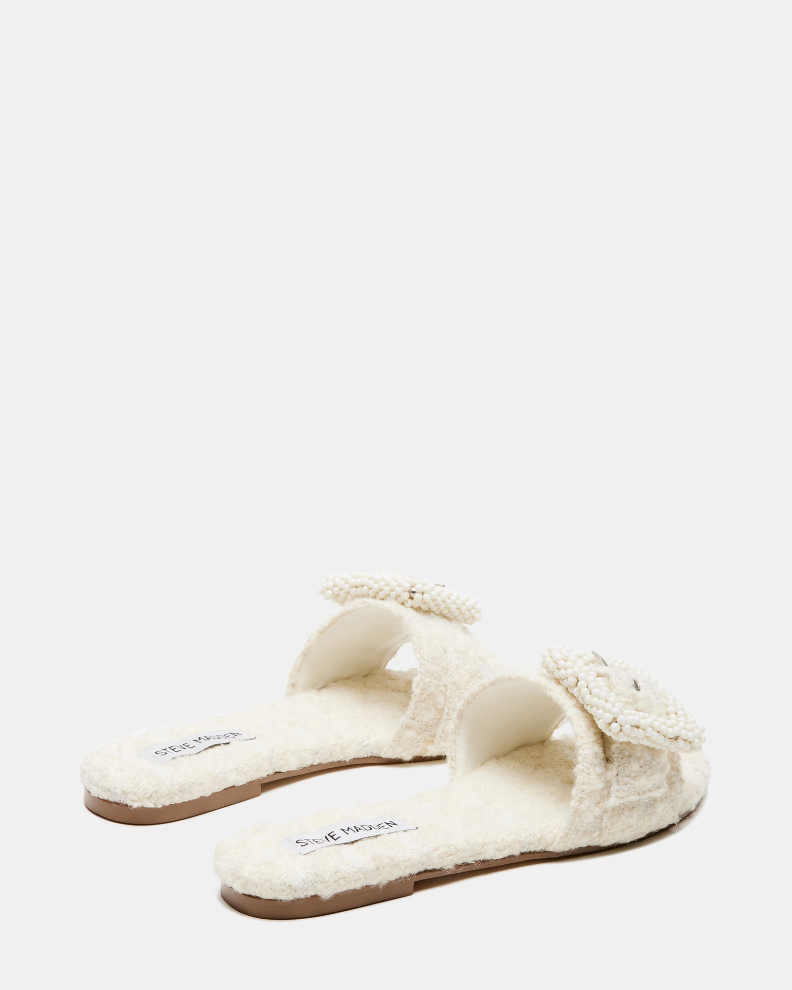 Side angle of flat sandal showing low heel and pearl-textured strap detail.