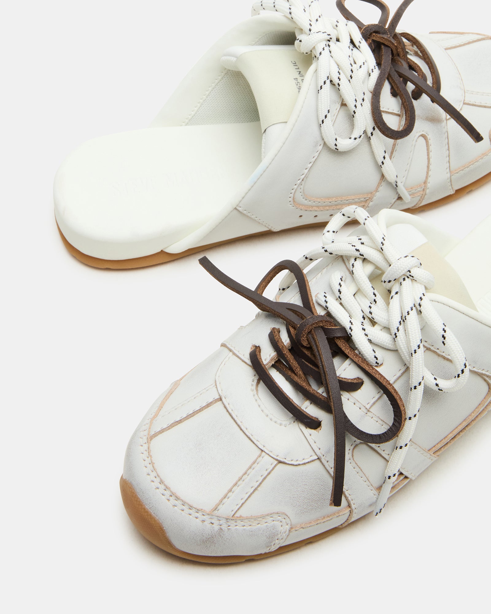Closeup of the Maysa distressed white shoes from side view, showing 1-inch heel and leather texture.