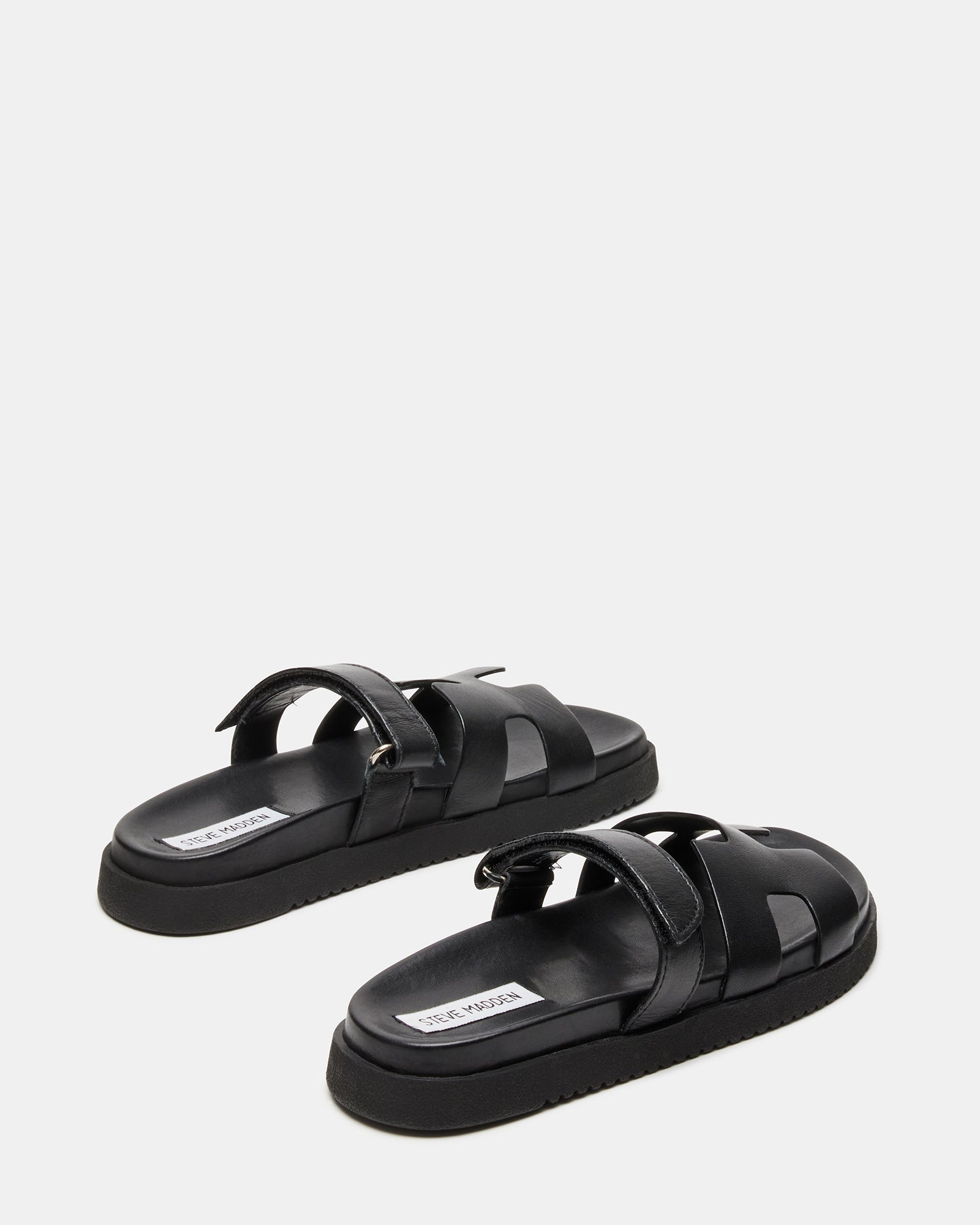 Lifestyle shot of MAYVEN slides worn during a casual outdoor event.