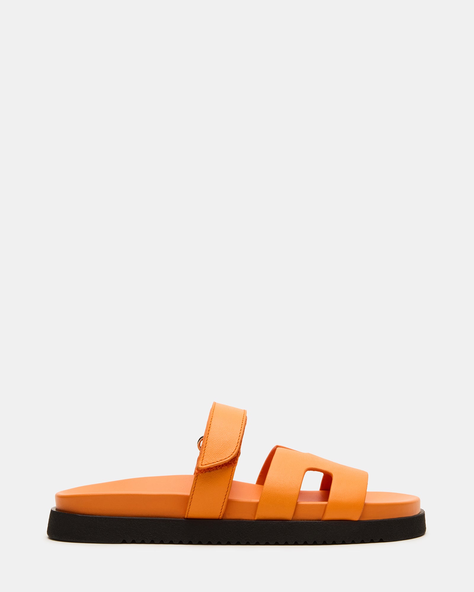 Side view of orange leather slides with geometric cutout design and platform sole